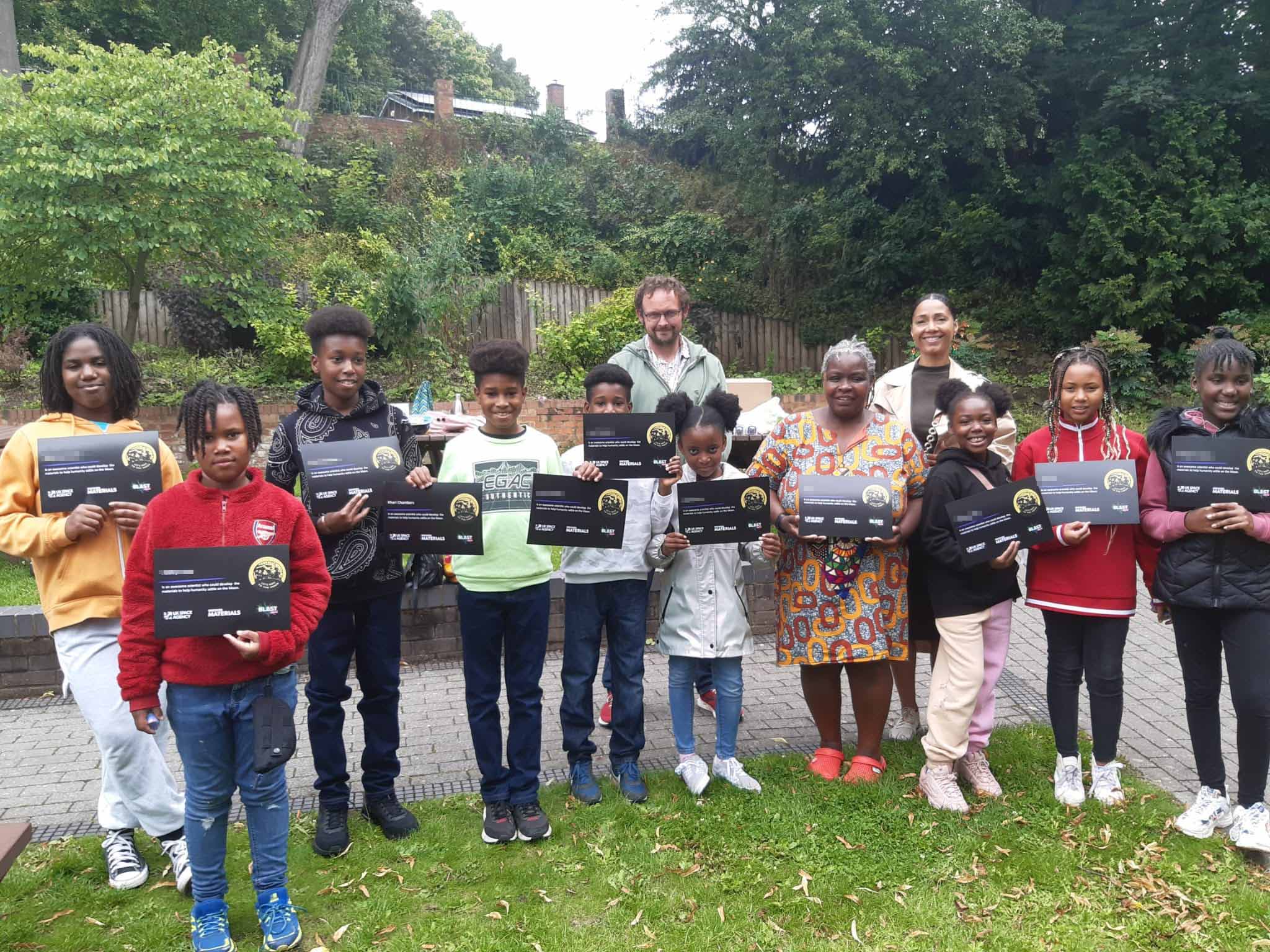 A group of school children and their educators holding award certificates