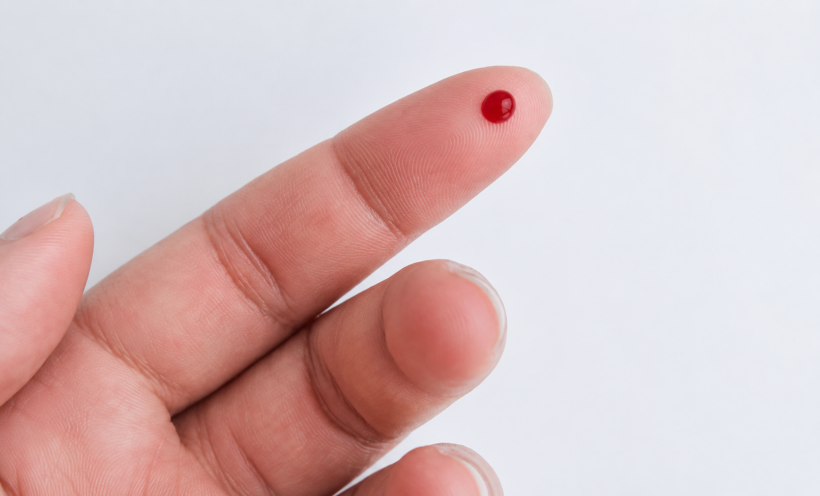 Close-up of a drop of blood on a fingertip