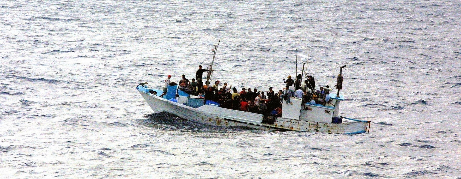 Small boat filled with people on the sea.
