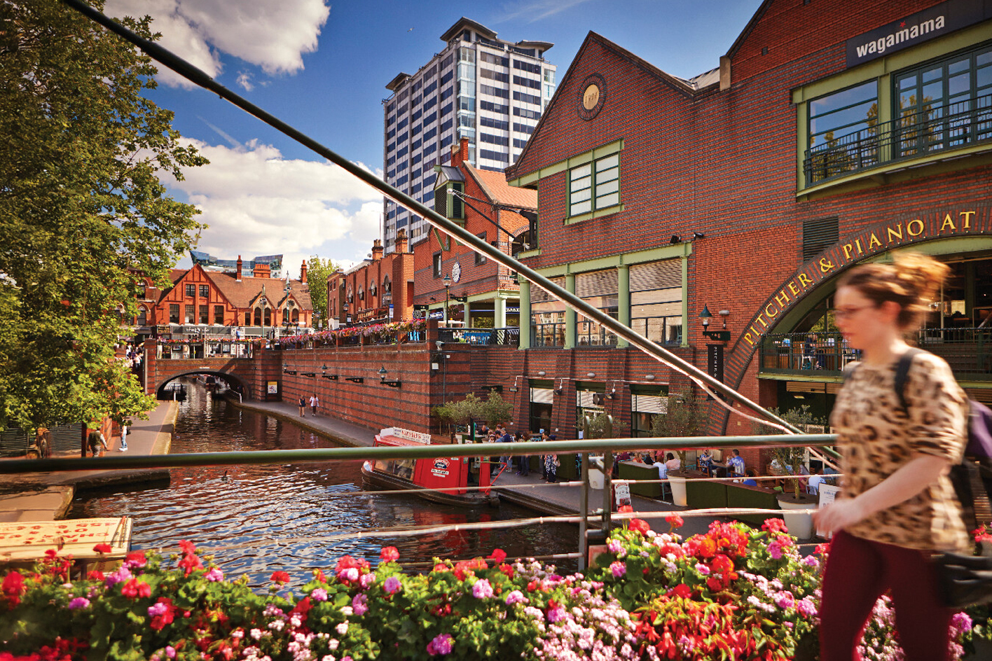 A view of the canal at Brindley Place with colourful flowers lining the bridge