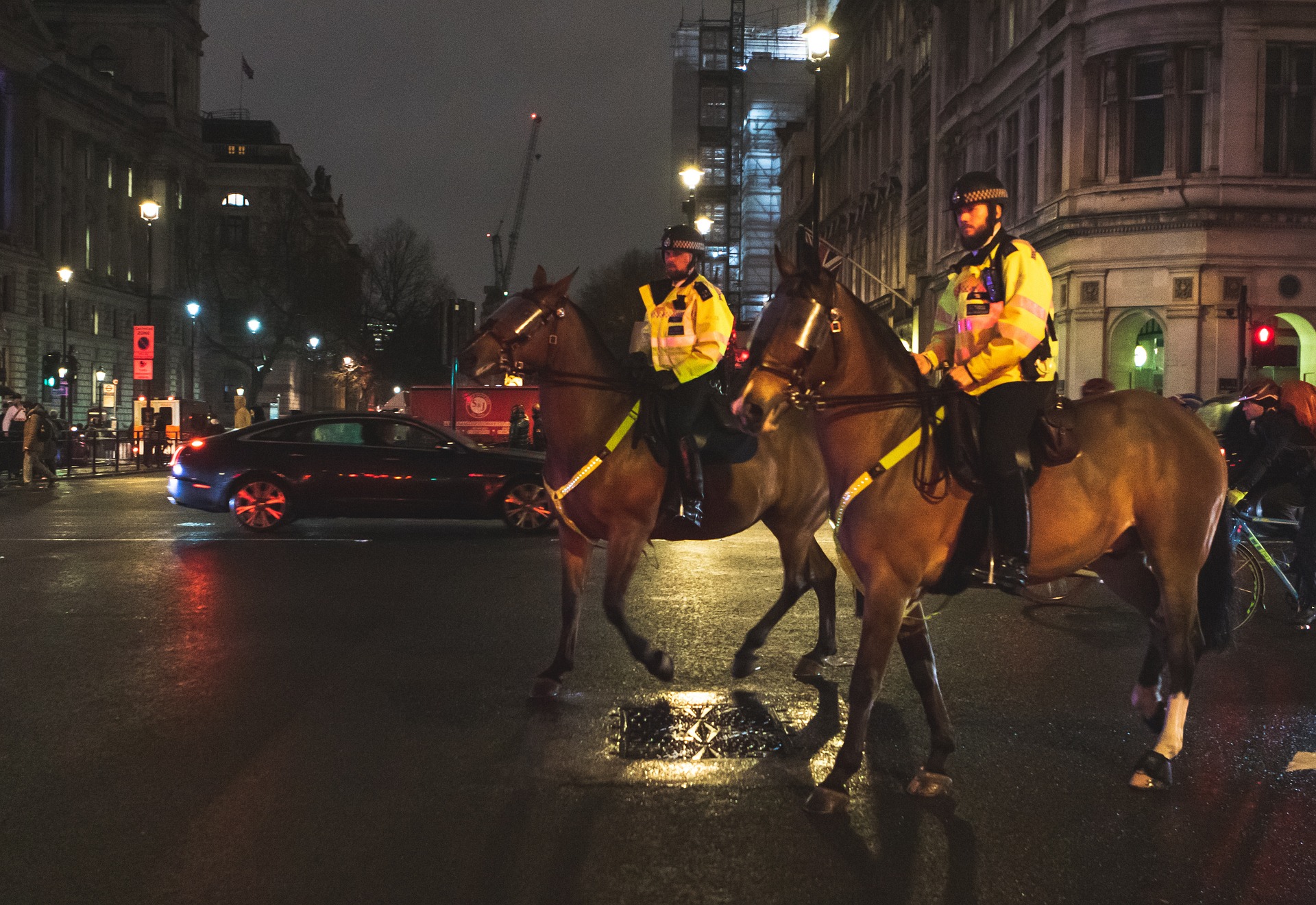 Two police officers on horseback at night in London.
