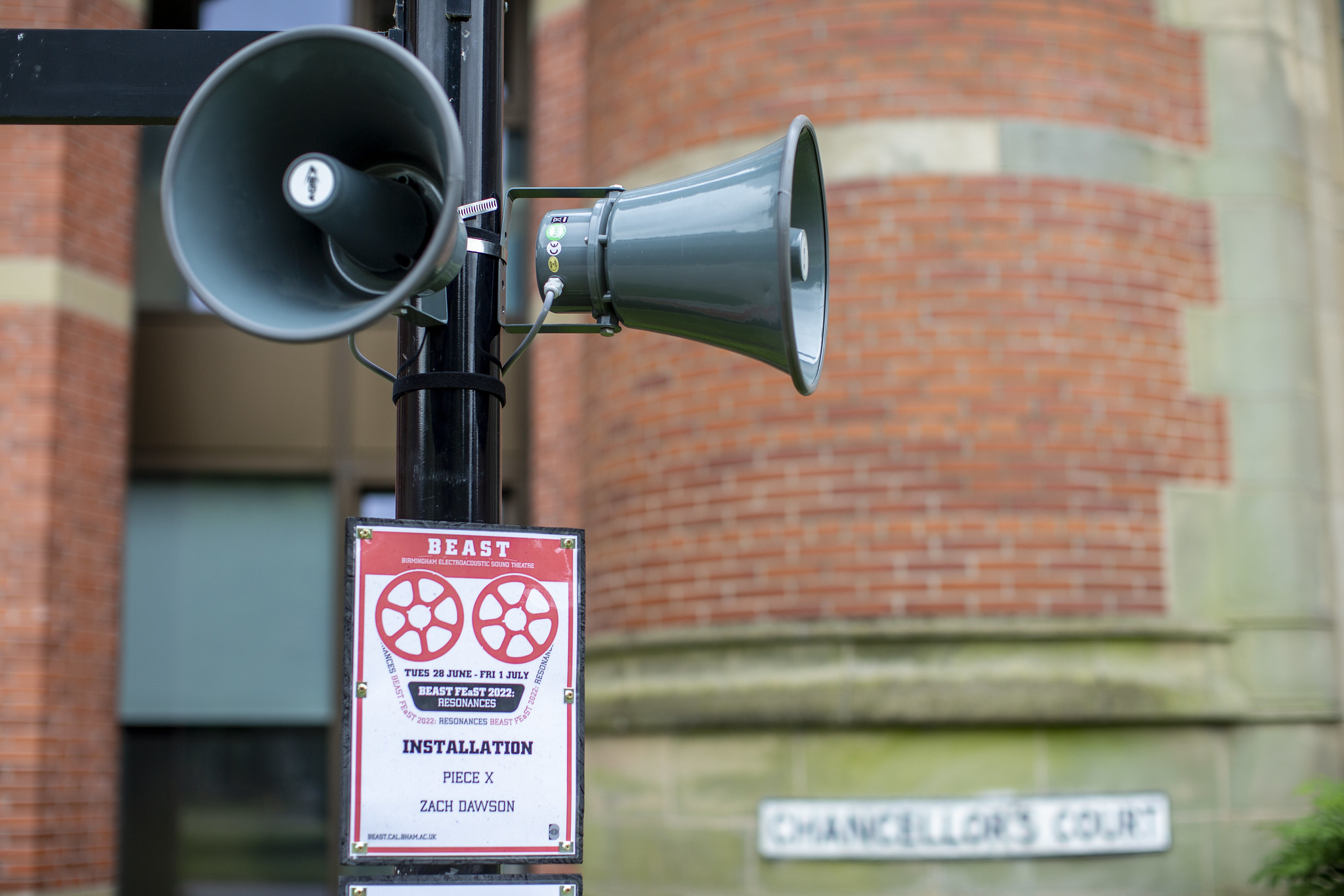 A poster on a lamppost with speakers