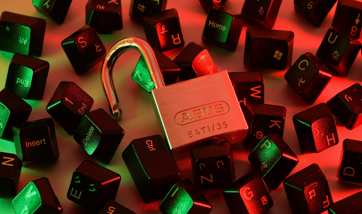 Computer keys surrounding an open padlock