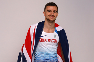 Sportsman dressed in Great Britain Olympic clothing against a blank background