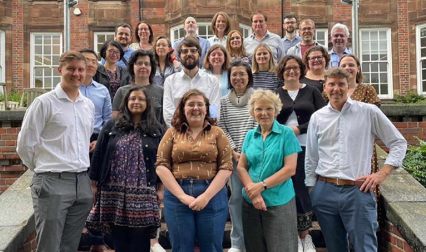Group picture of 20 people on steps infront of an old building