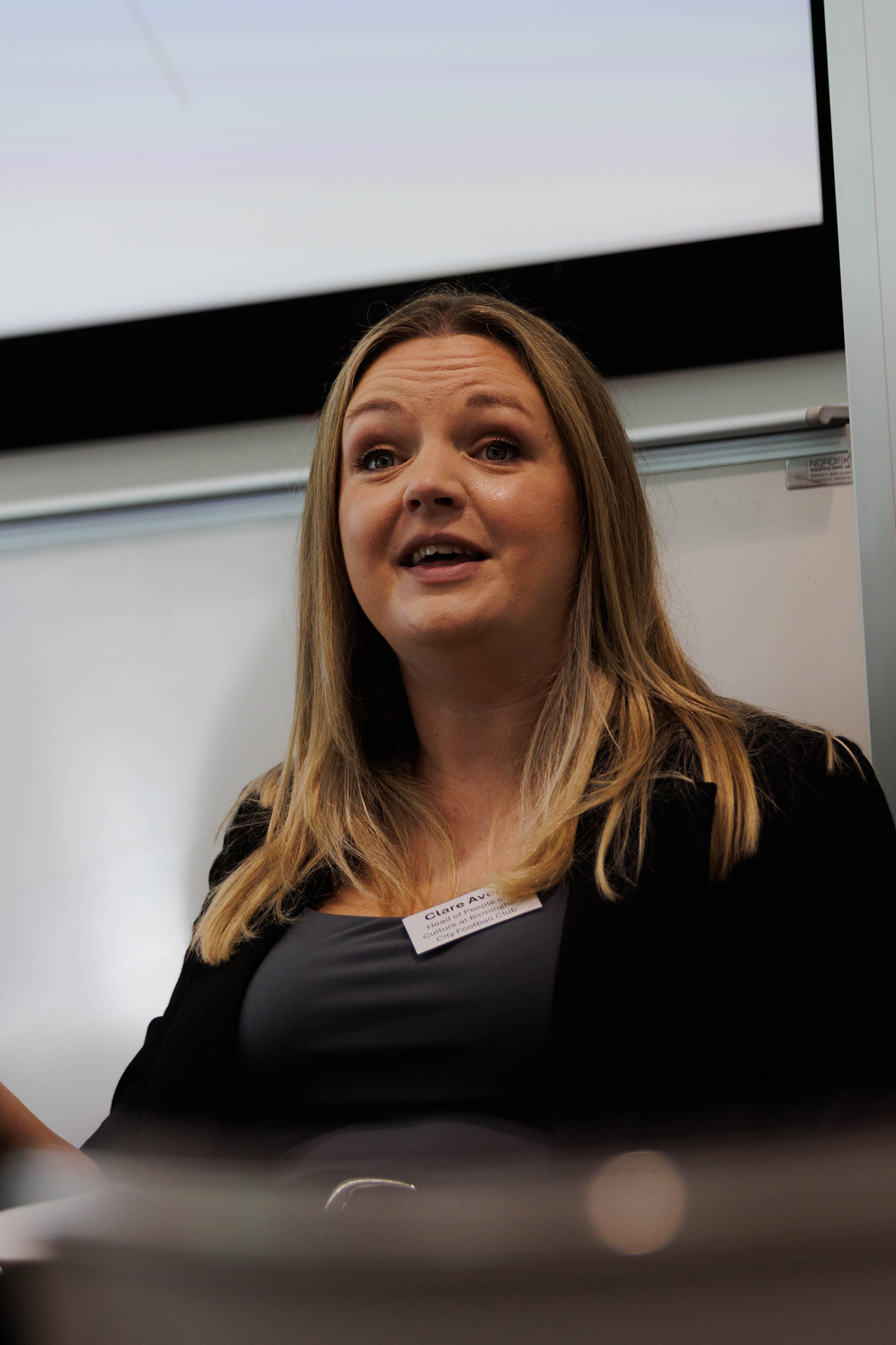 Woman in business dress talking at a conference