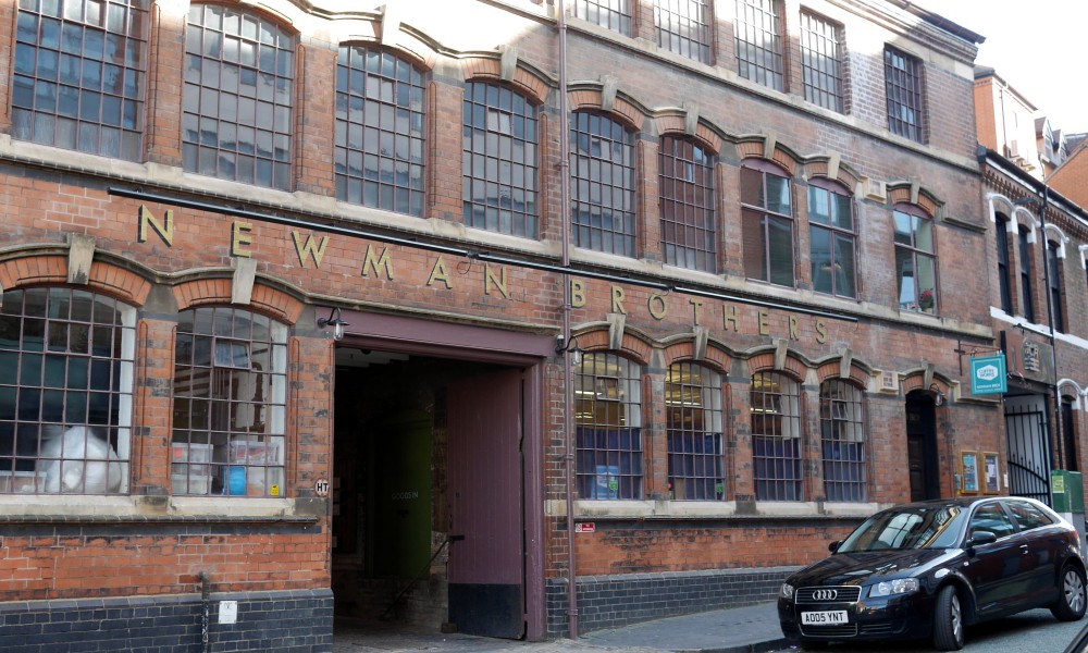 Exterior of brick factory, with Newman Brothers stencilled over the doors