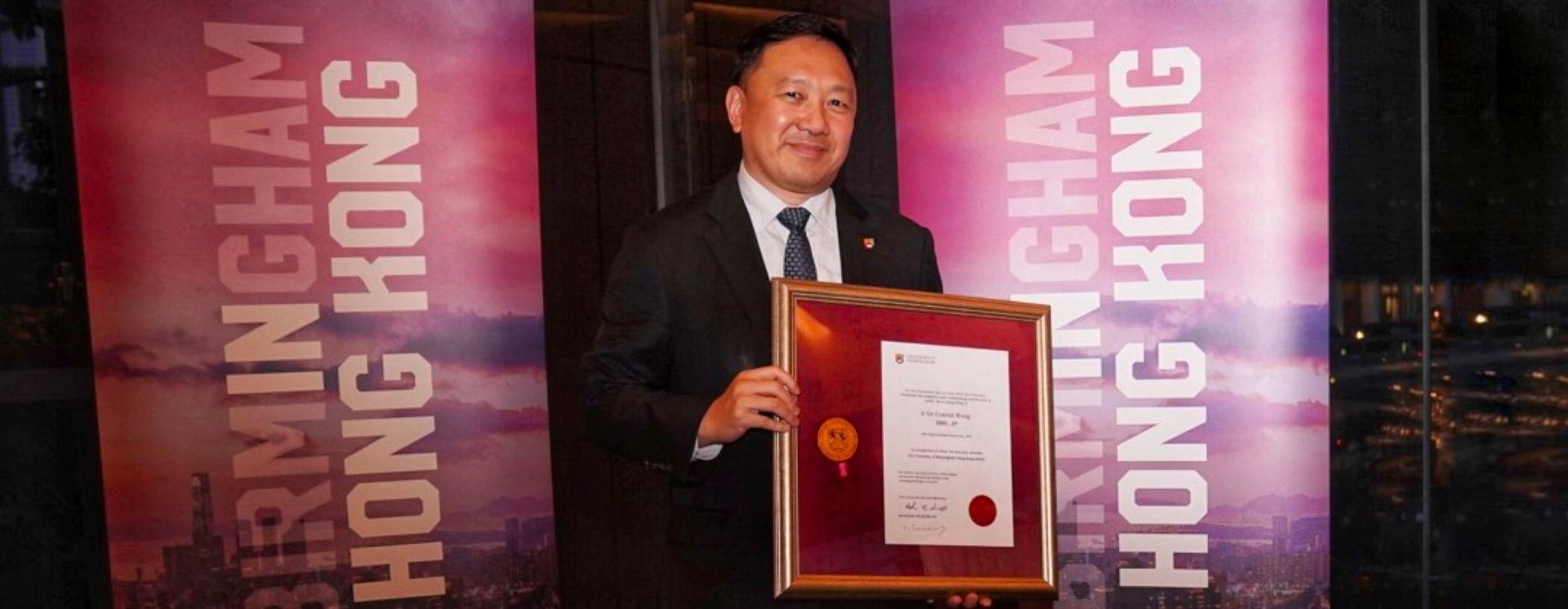 Dr Conrad Wong holding his framed Hong Kong medal