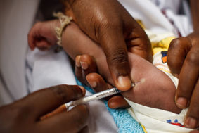 Doctor in Africa giving a baby a vaccine. 