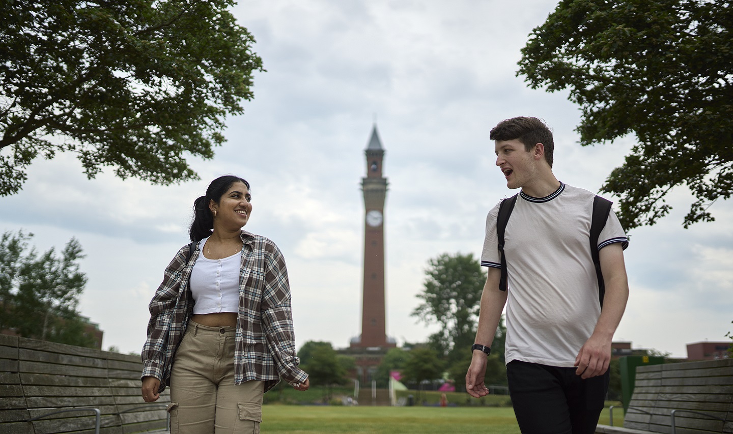 Two young people standing in front of clock tower