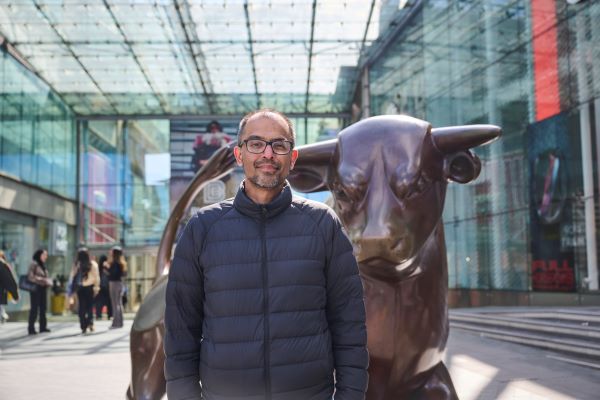 Man stood in front of bull statue in Birmingham Bullring