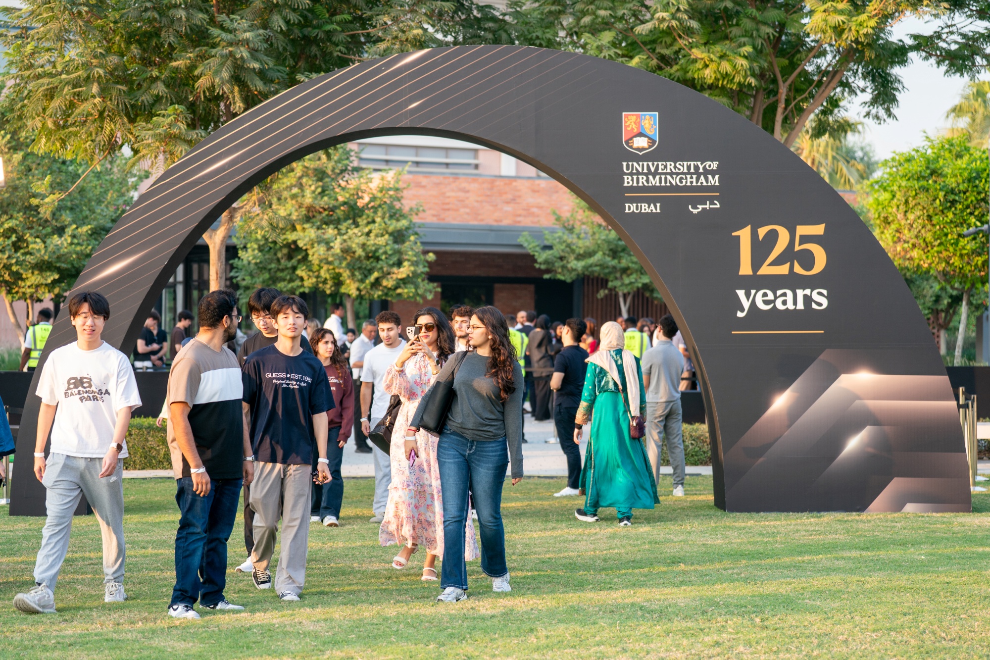 Students walking into a festival inside a park.