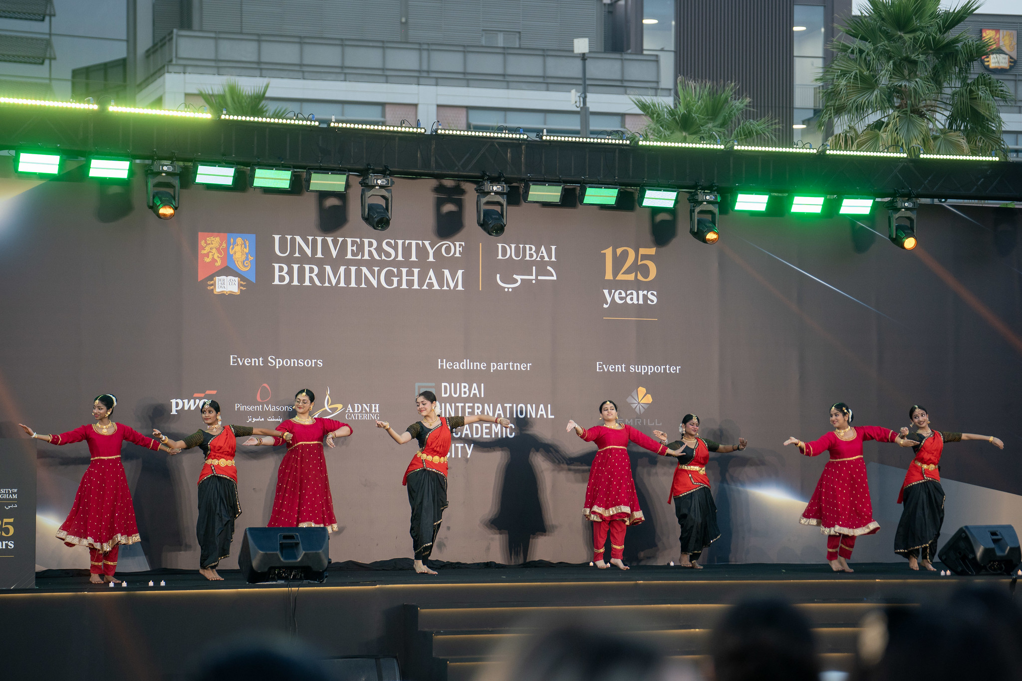 Dance group performing on stage during the University of Birmingham Dubai 125th anniversary event.