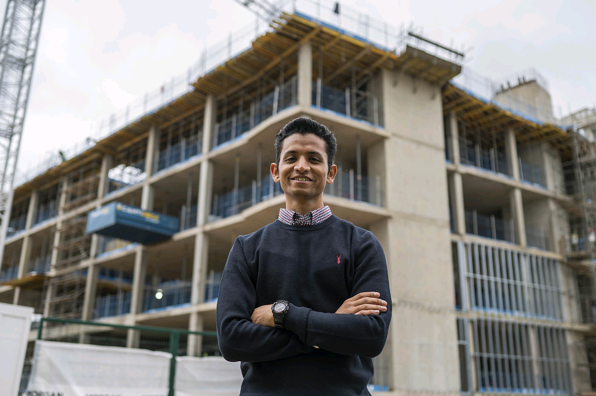 Image Haripreeth standing in front of building which is under construction