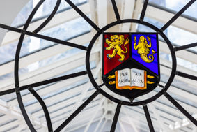 A stained glass window depicting the University of Birmingham crest.