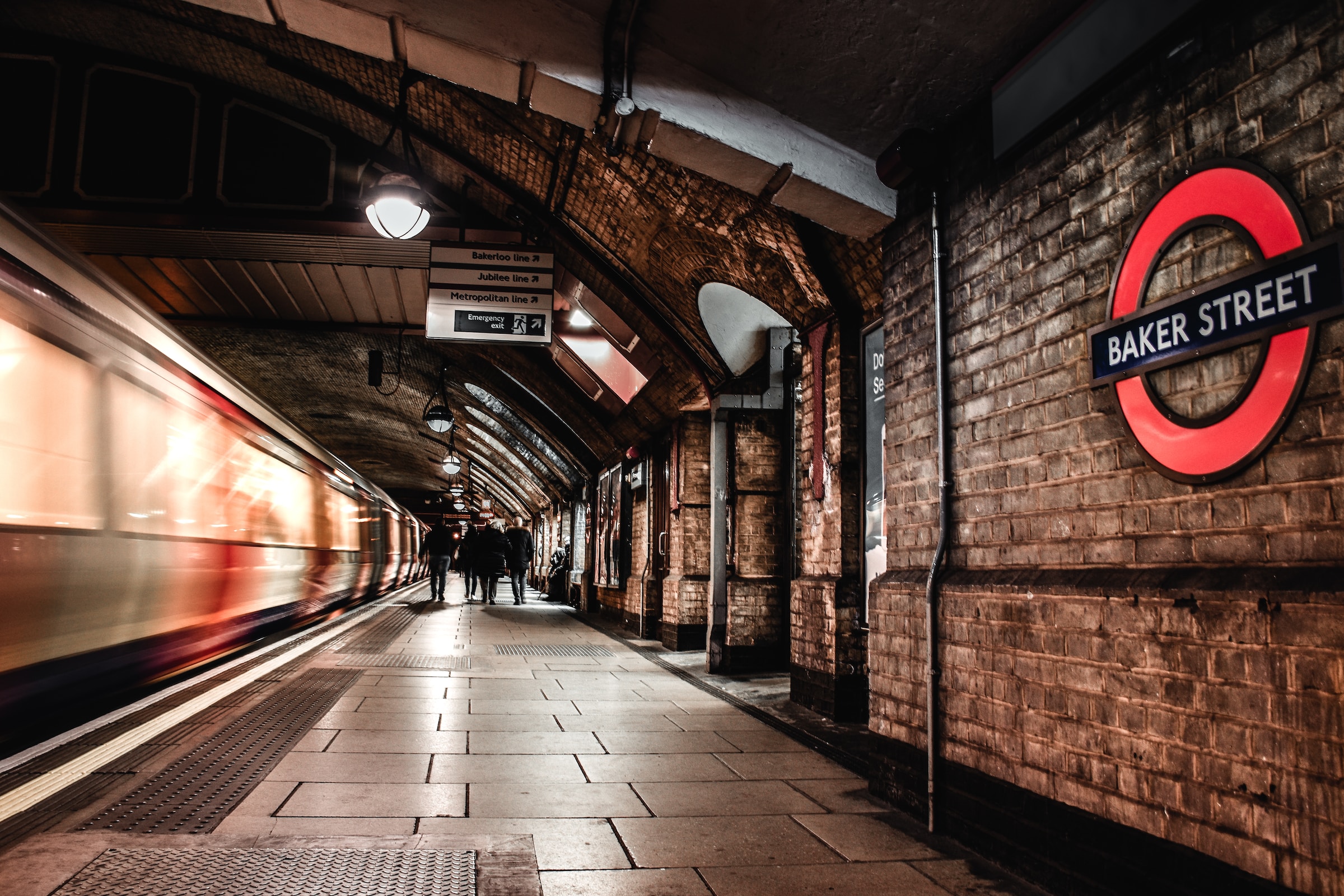 A platform at Baker Street Underground station in London, with a train speeding by