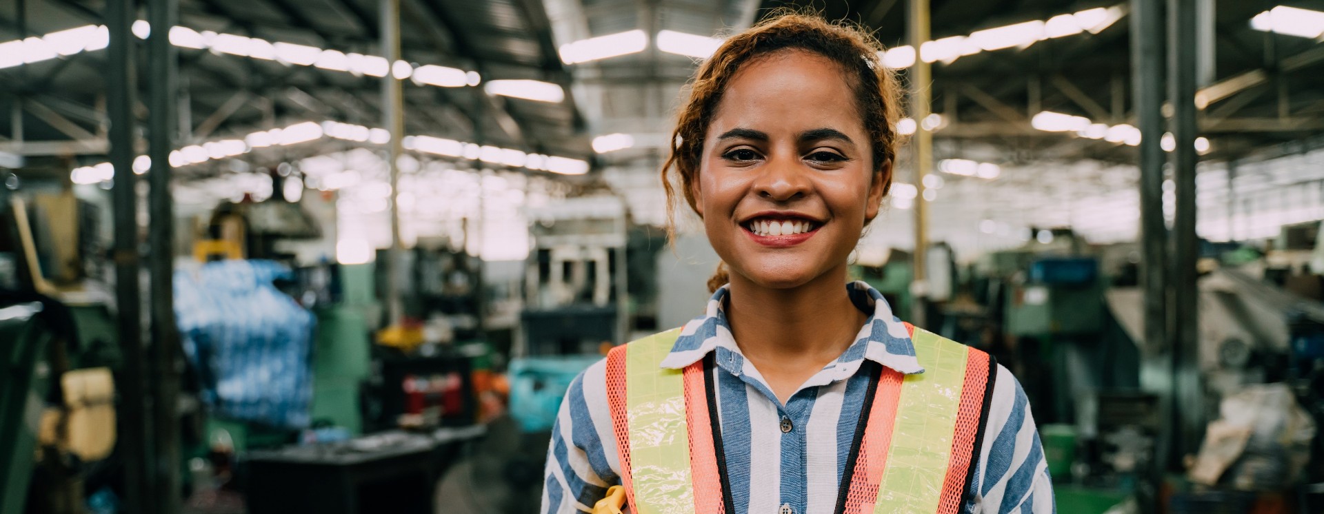 Woman wearing hi-viz jacket in a factory 