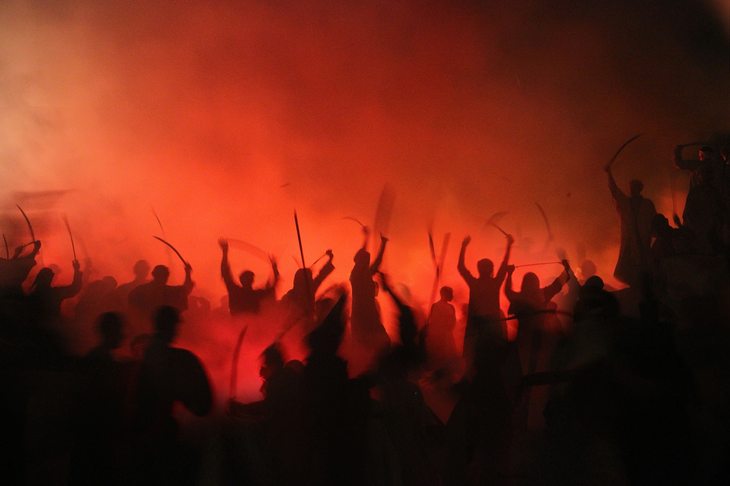 Rioters silhouetted against the smokey orange glow of flames