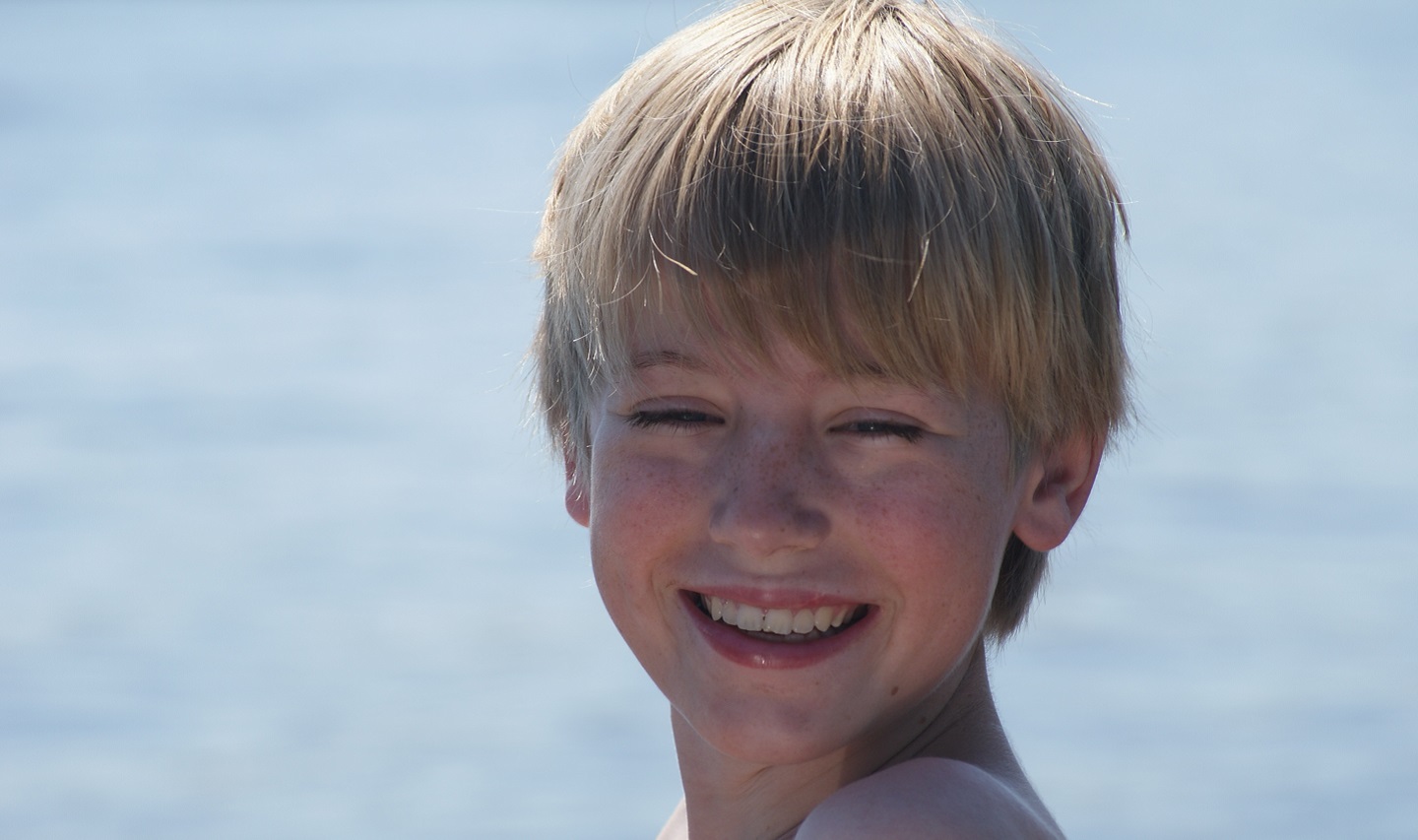 Young boy with water in background
