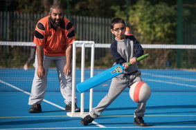 Young person trying out blind cricket.