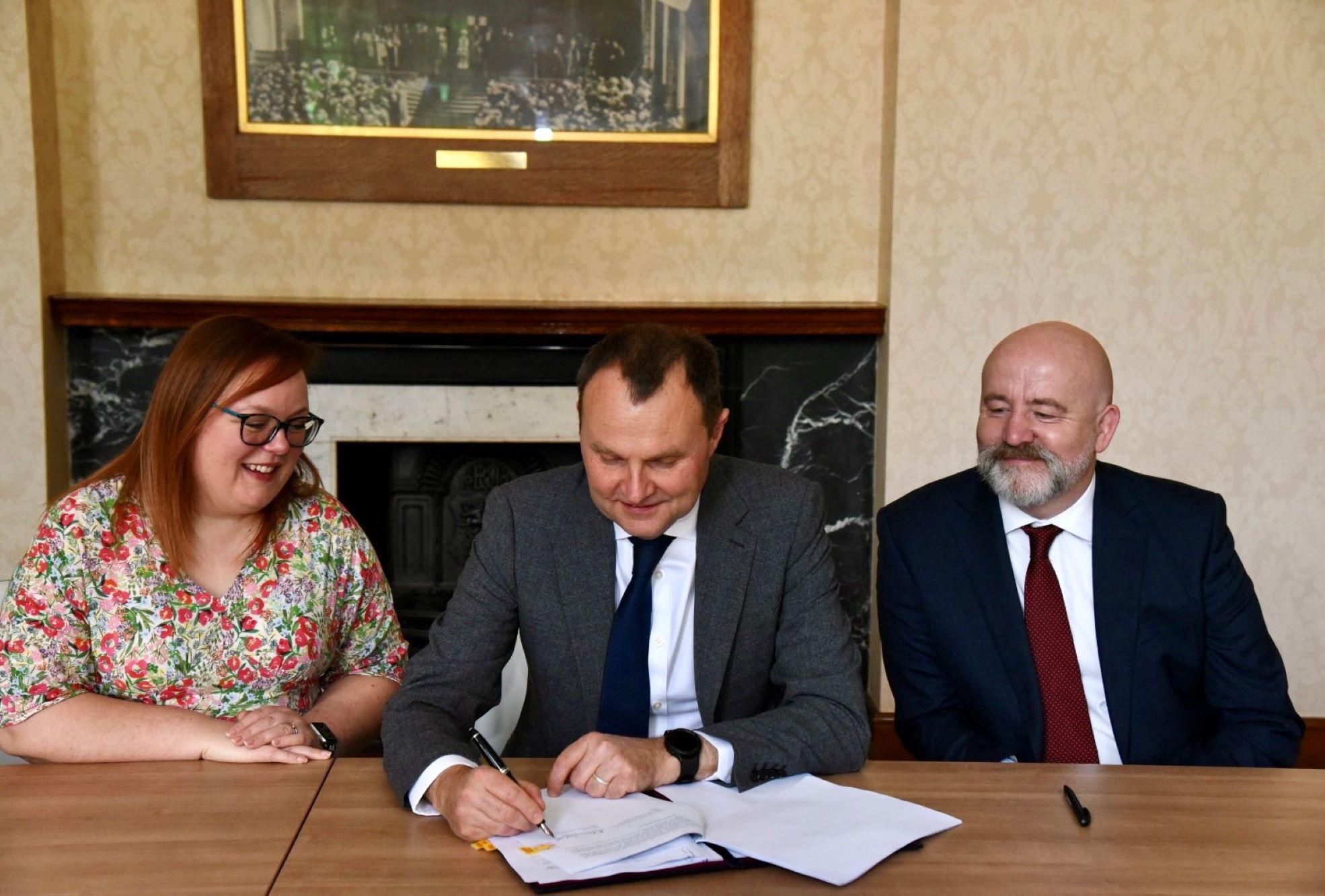 Professor Adam Tickell, Vice-Chancellor of the University of Birmingham, signs the agreement with IIT Madras, watched by TNE Officer Rachel du Croz and Mark Lee, Professor of Artificial Intelligence.