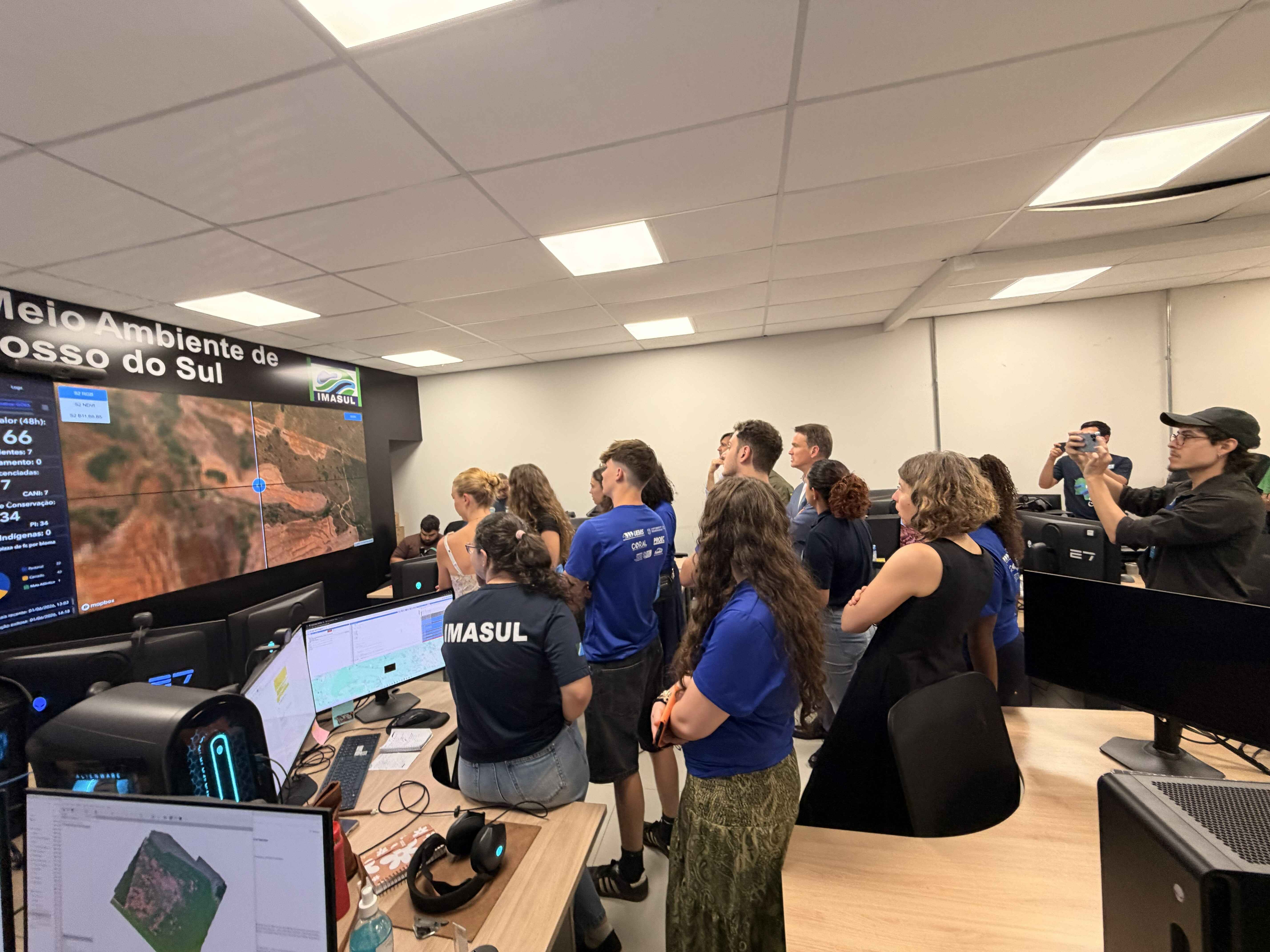 IMASUL technicians explaining the fire monitoring using a digital tecnhology display