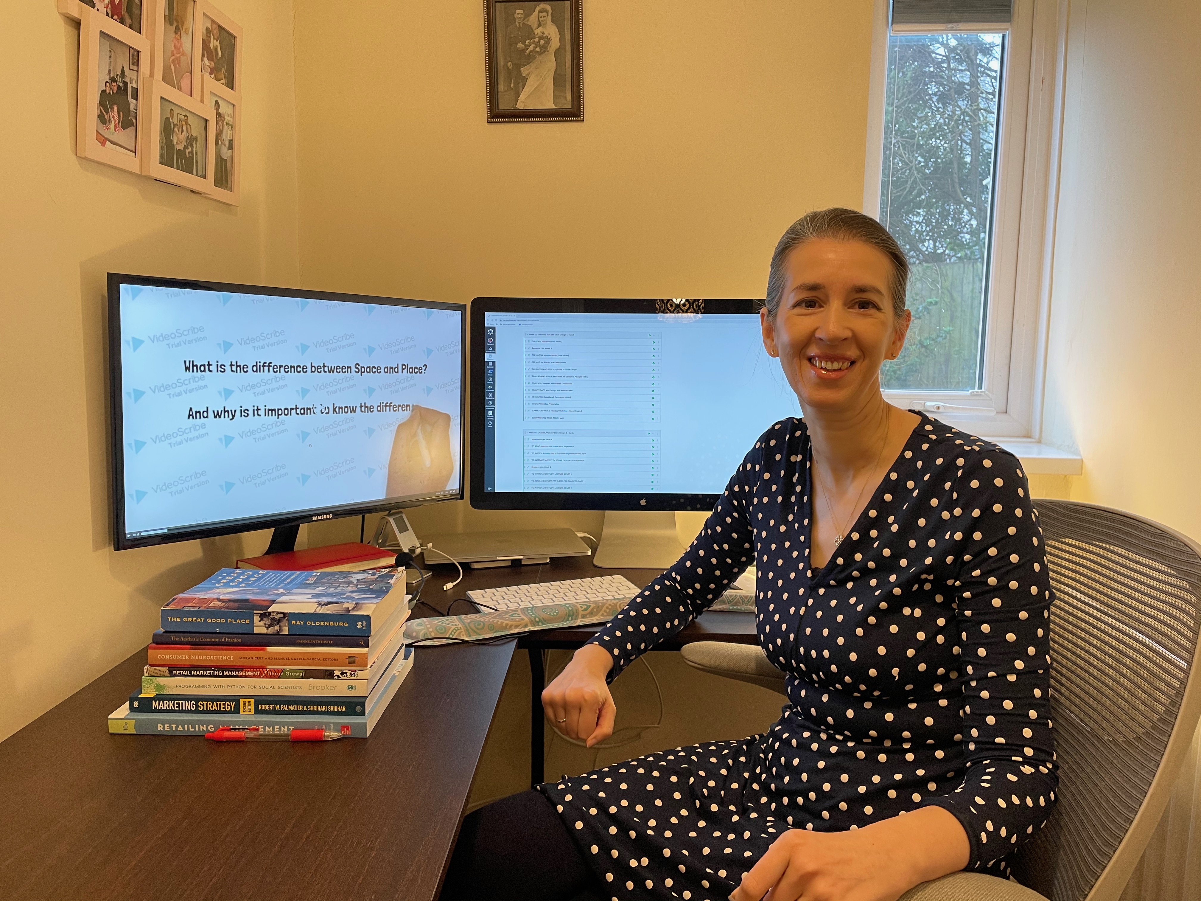 Professor Sarah Montano sitting at her desk with books and her computer displaying. 