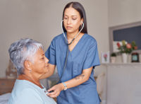 Healthcare professional listening to the heartbeat of an elderly patient
