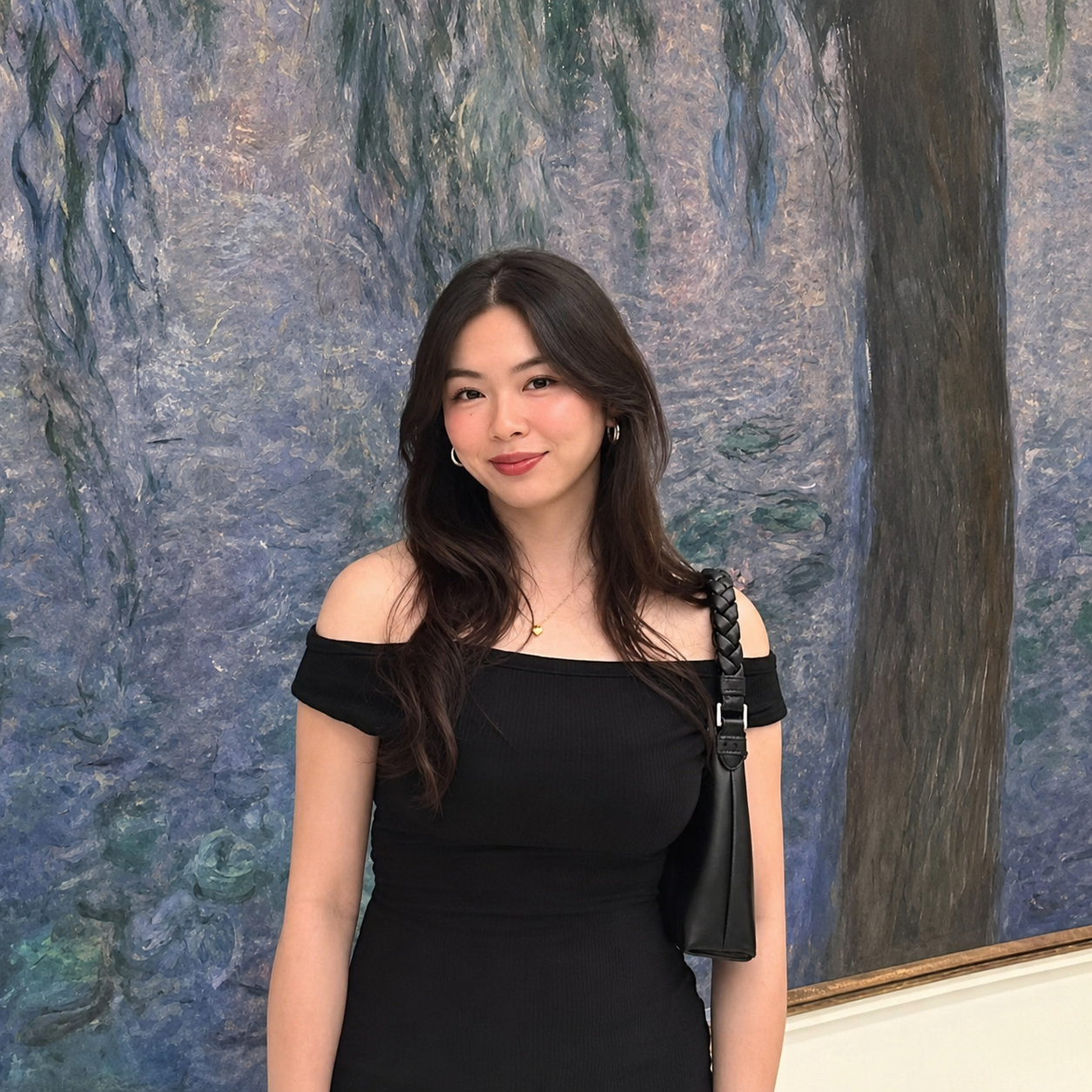 Janette smiles in front of a painting