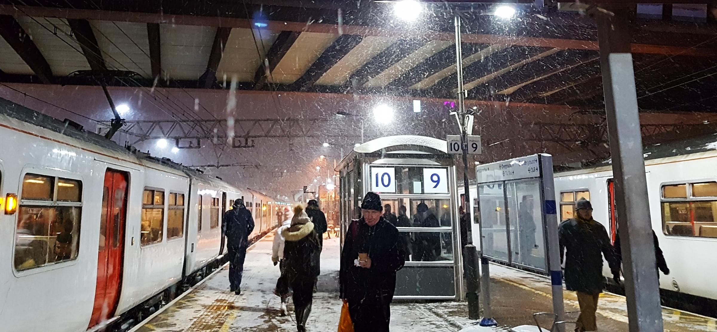 Passengers on a snowy rail station platform