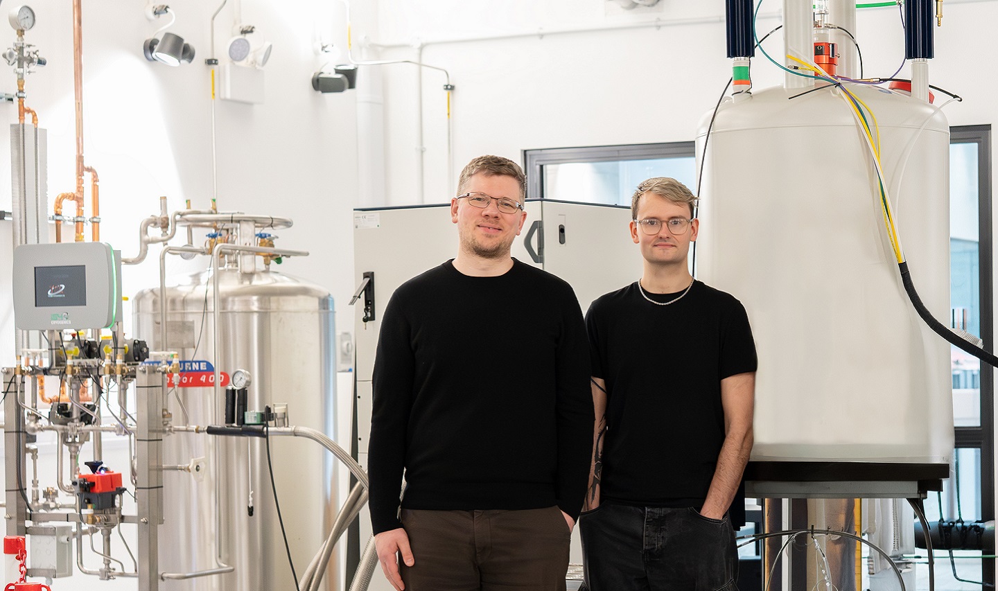 Two scientists standing in front of lab equipment