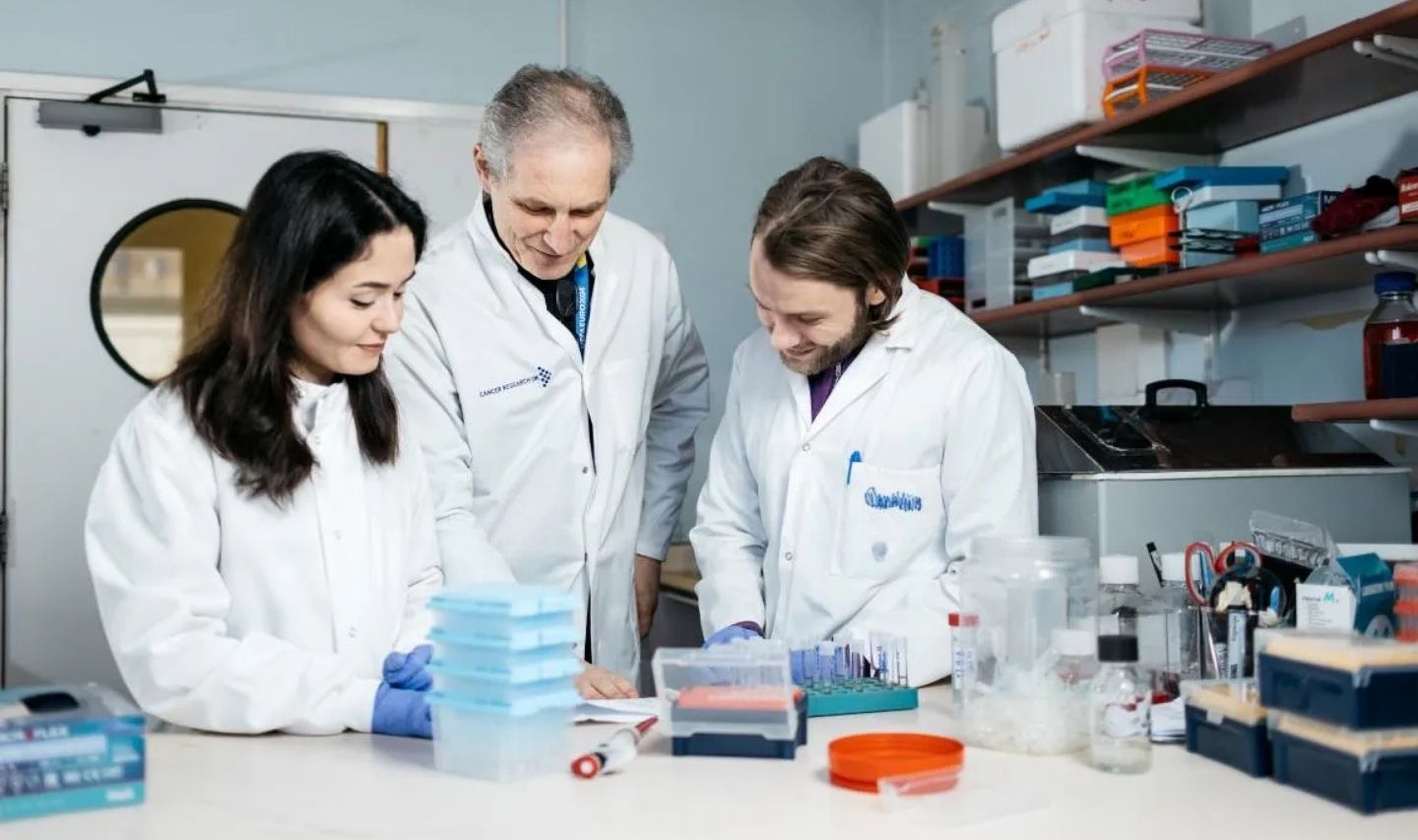 Three researchers working collaboratively in a laboratory 