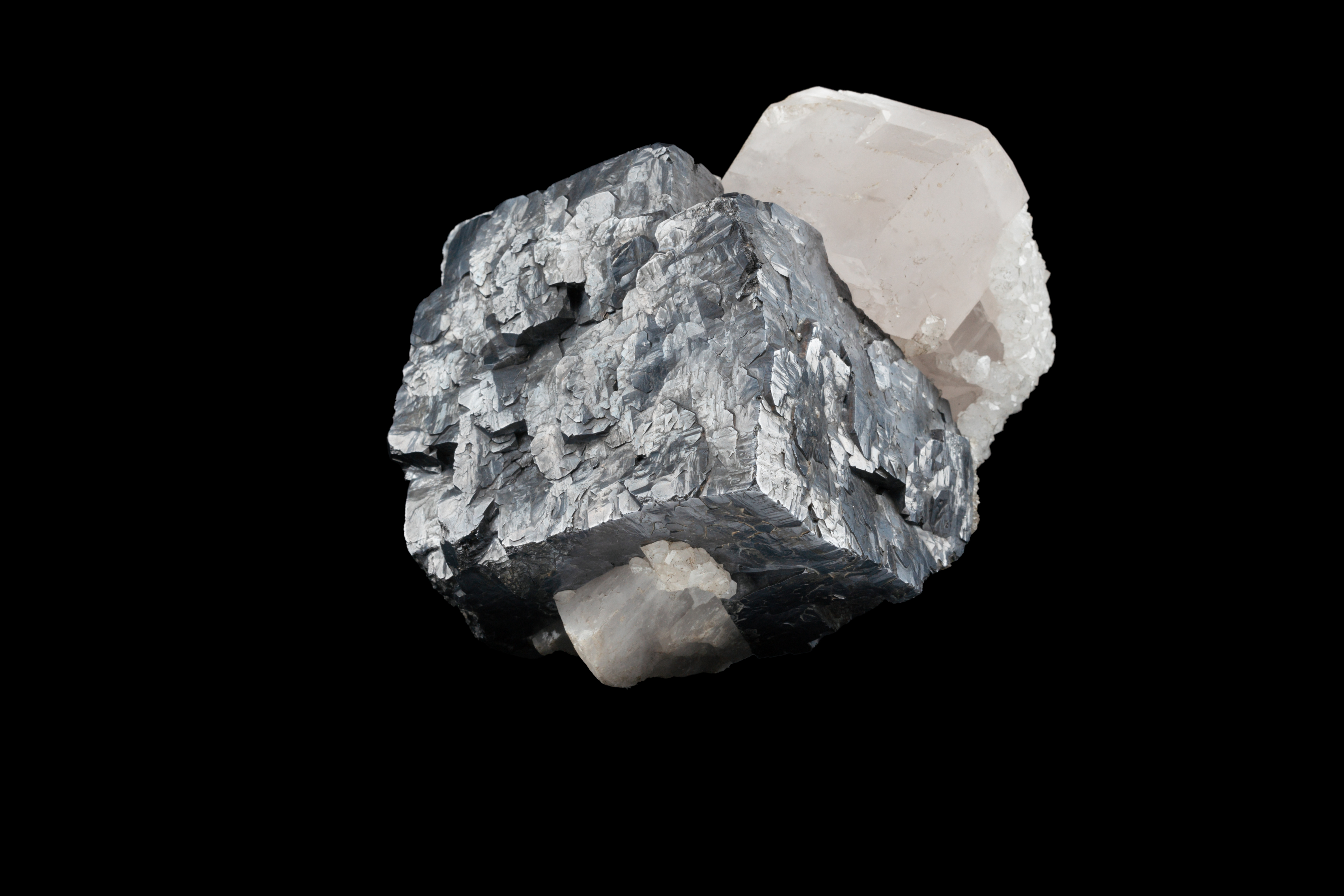 A cube of galena with calcite and milky quartz.