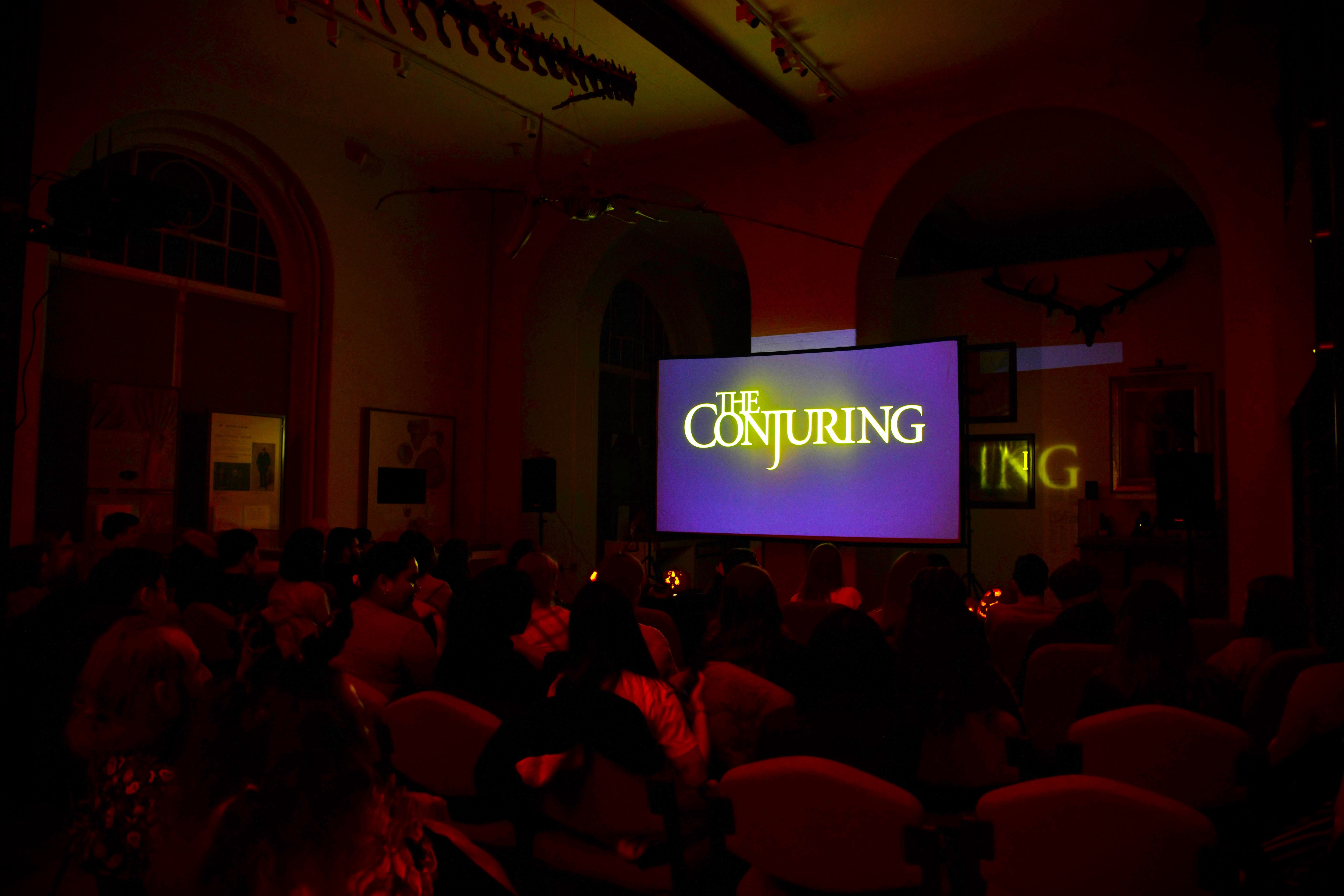 A crowd watches The Conjuring in the Lapworth Museum galleries.