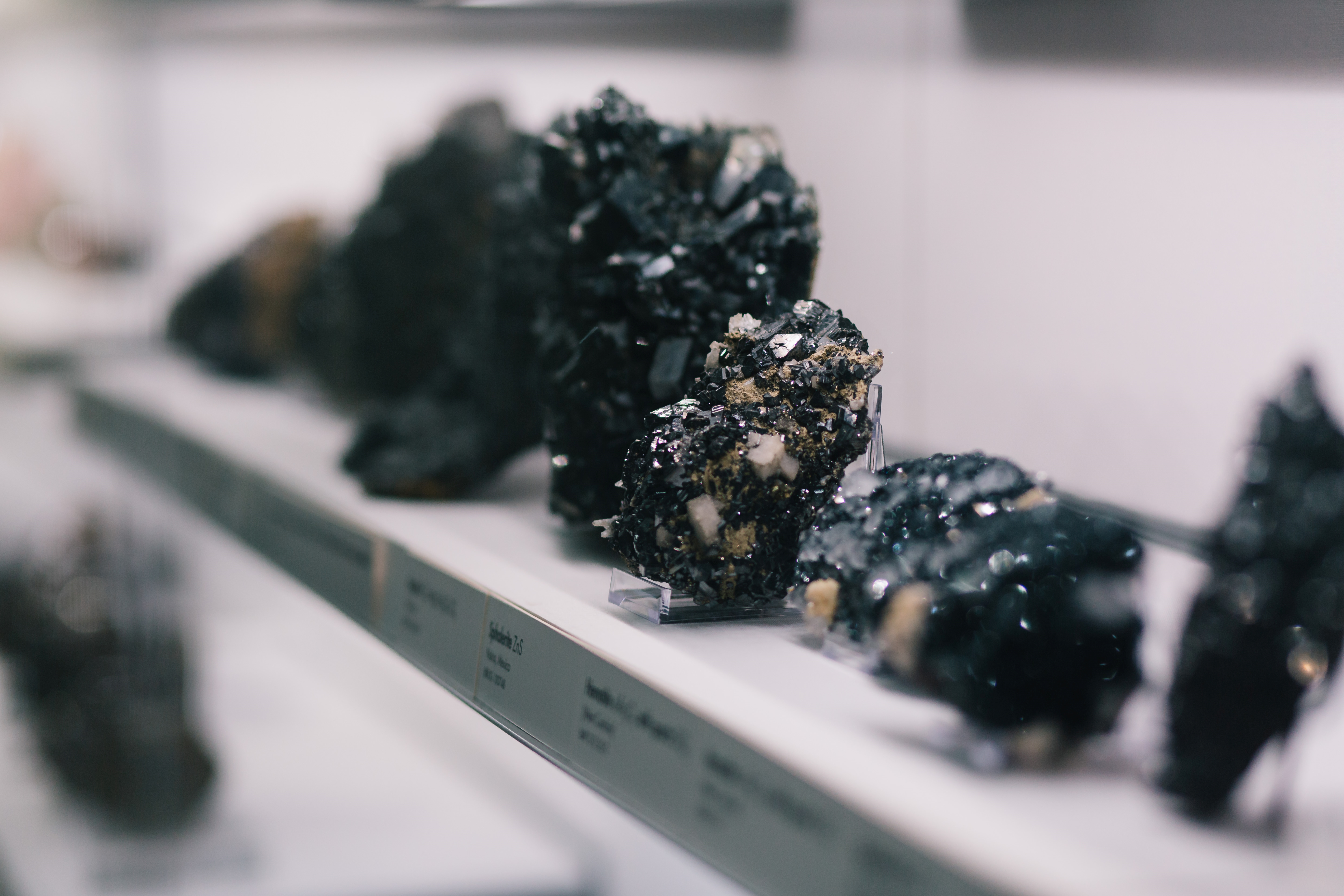 A series of black minerals on display.