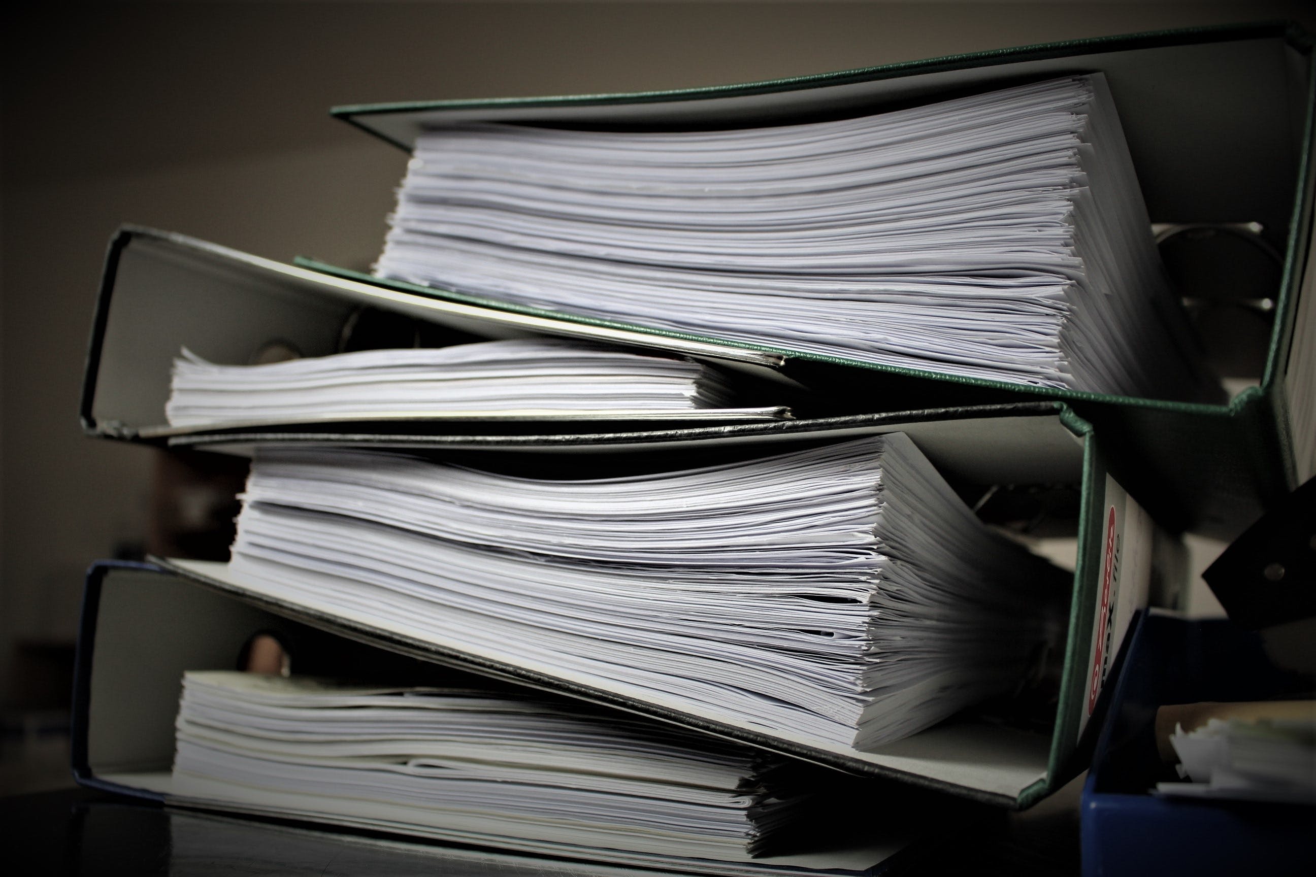A stack of four thick legal folders with case notes and other information