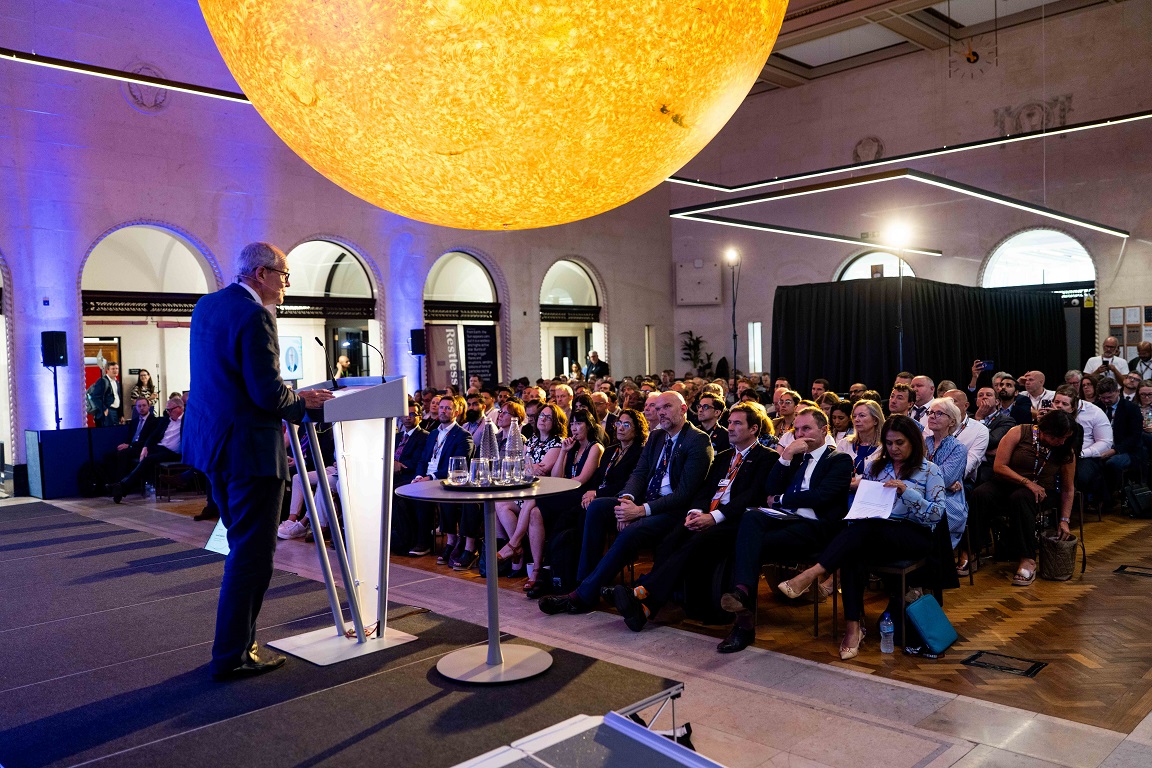 Lord Vallance speaking to a crowd of people