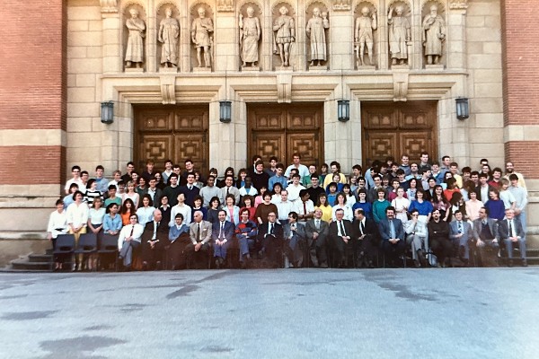 large group of staff and students sitting outside Aston Webb building