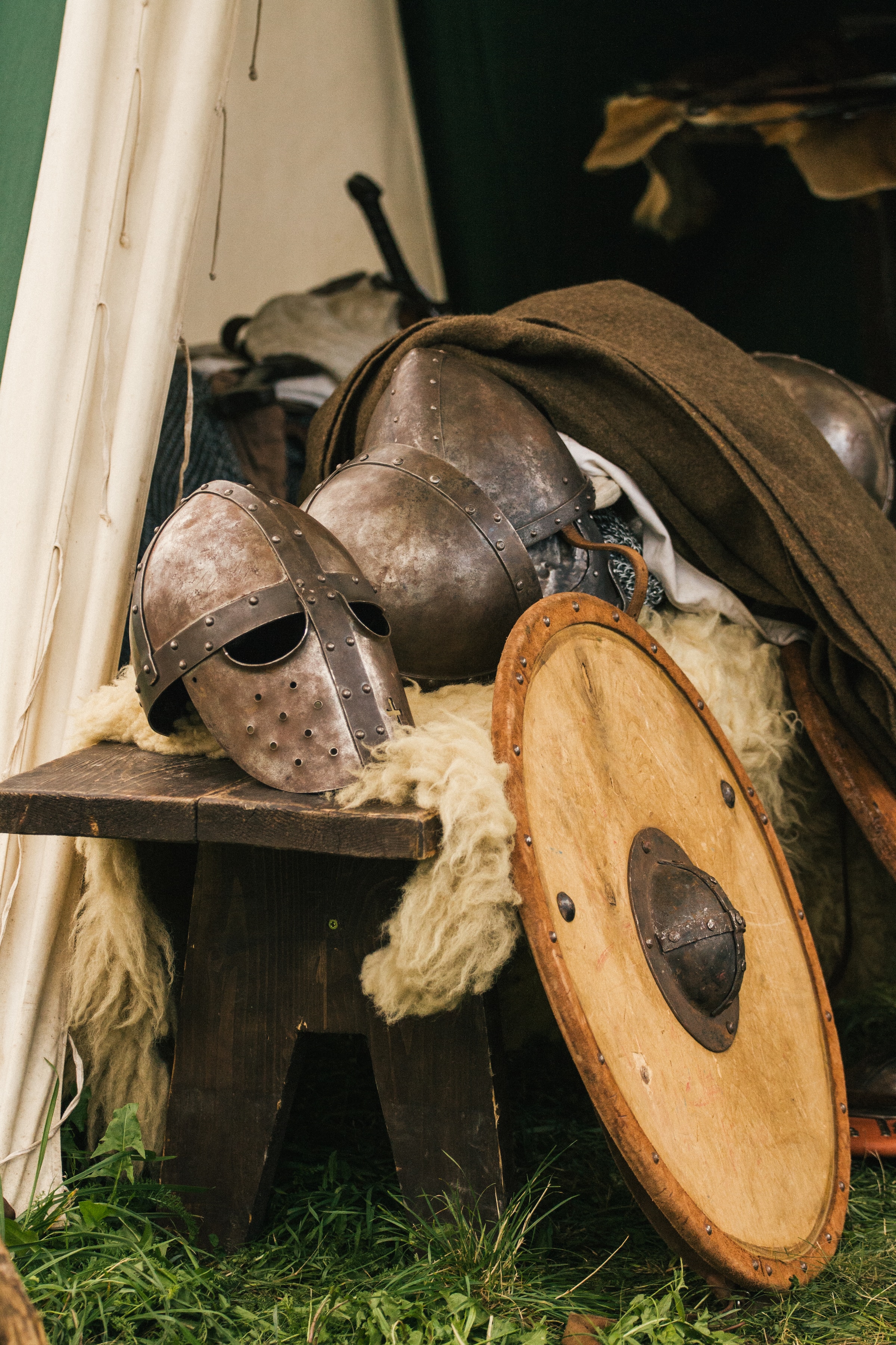Medieval helmets and shields on an old wooden table
