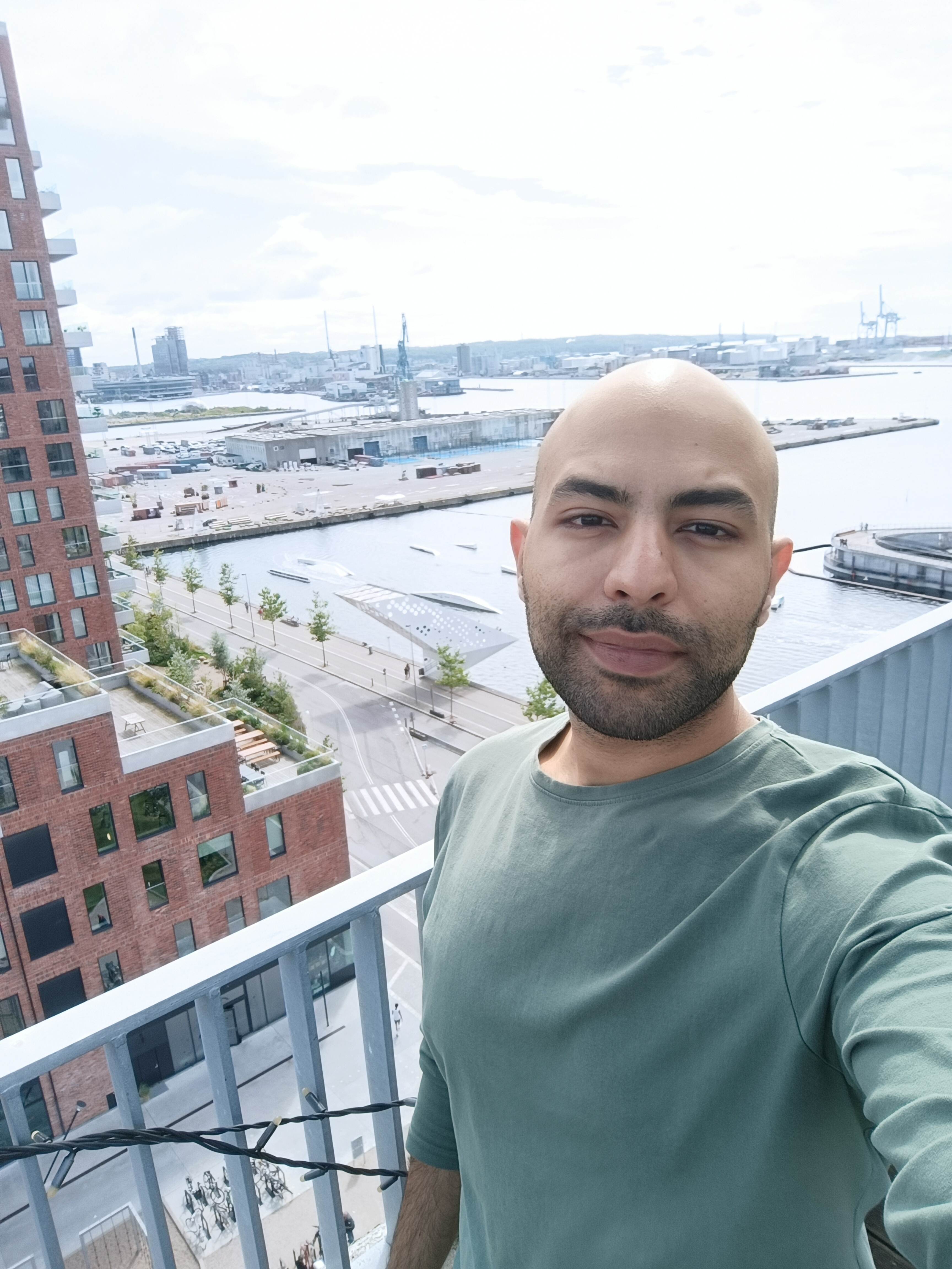Mohammed smiling over a view of block buildings