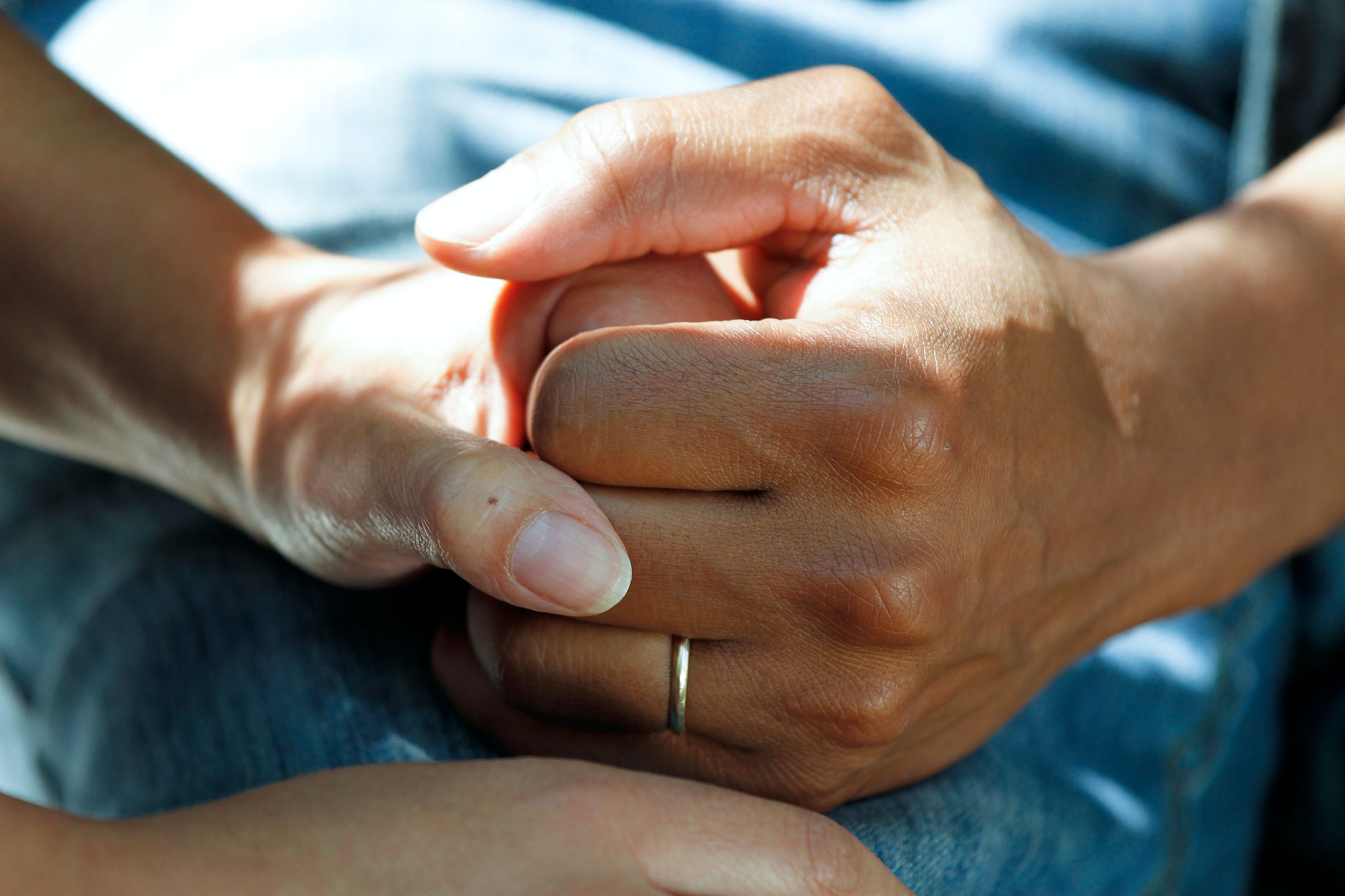 Close-up of two people's hands clasped together