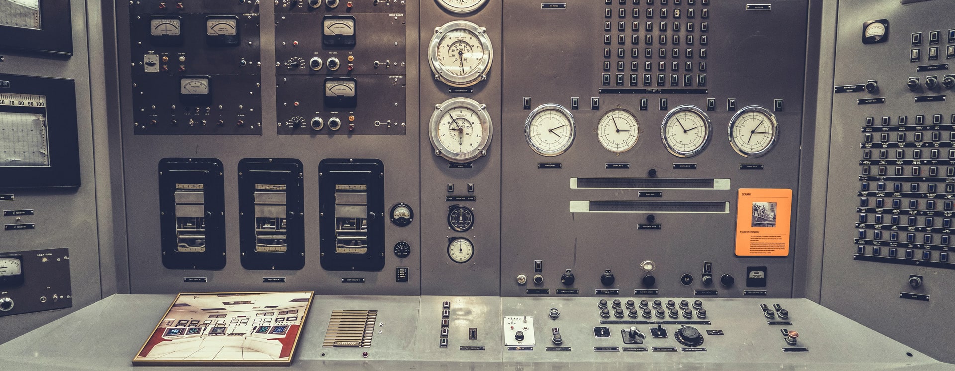 Control panel for nuclear reactor built in the 1950s with an array of buttons, dials and gauges
