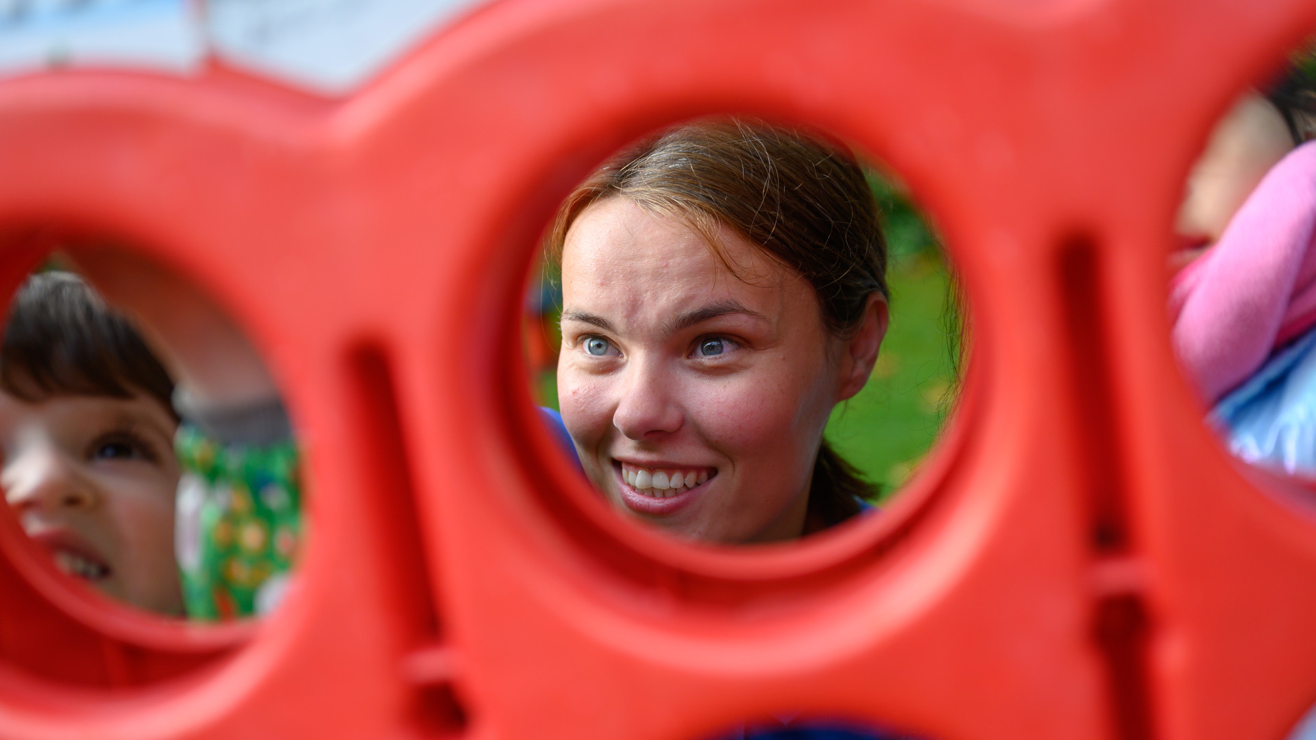 A nursery staff member playing 3 in a row with a child