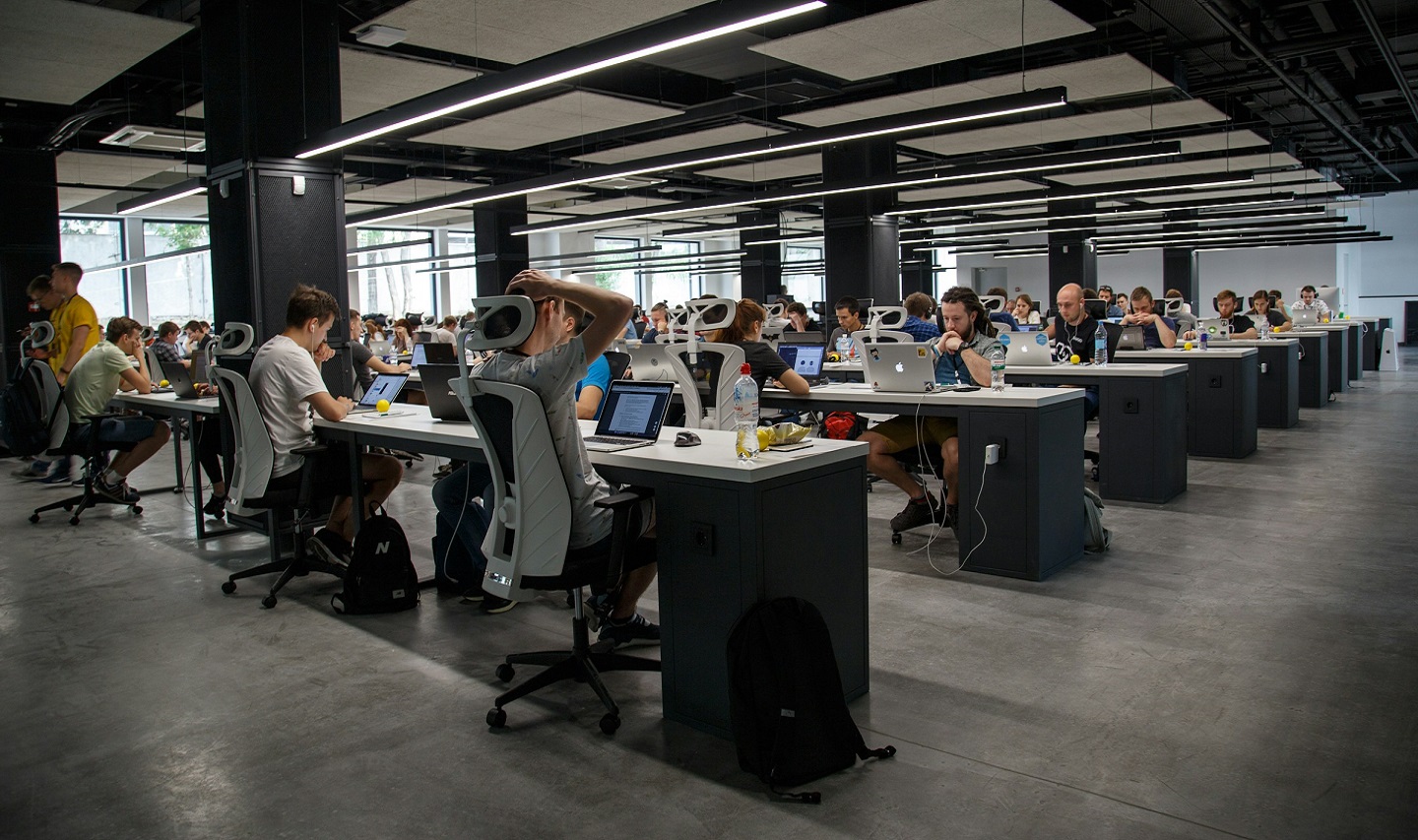 Rows of workers at long desks in an office