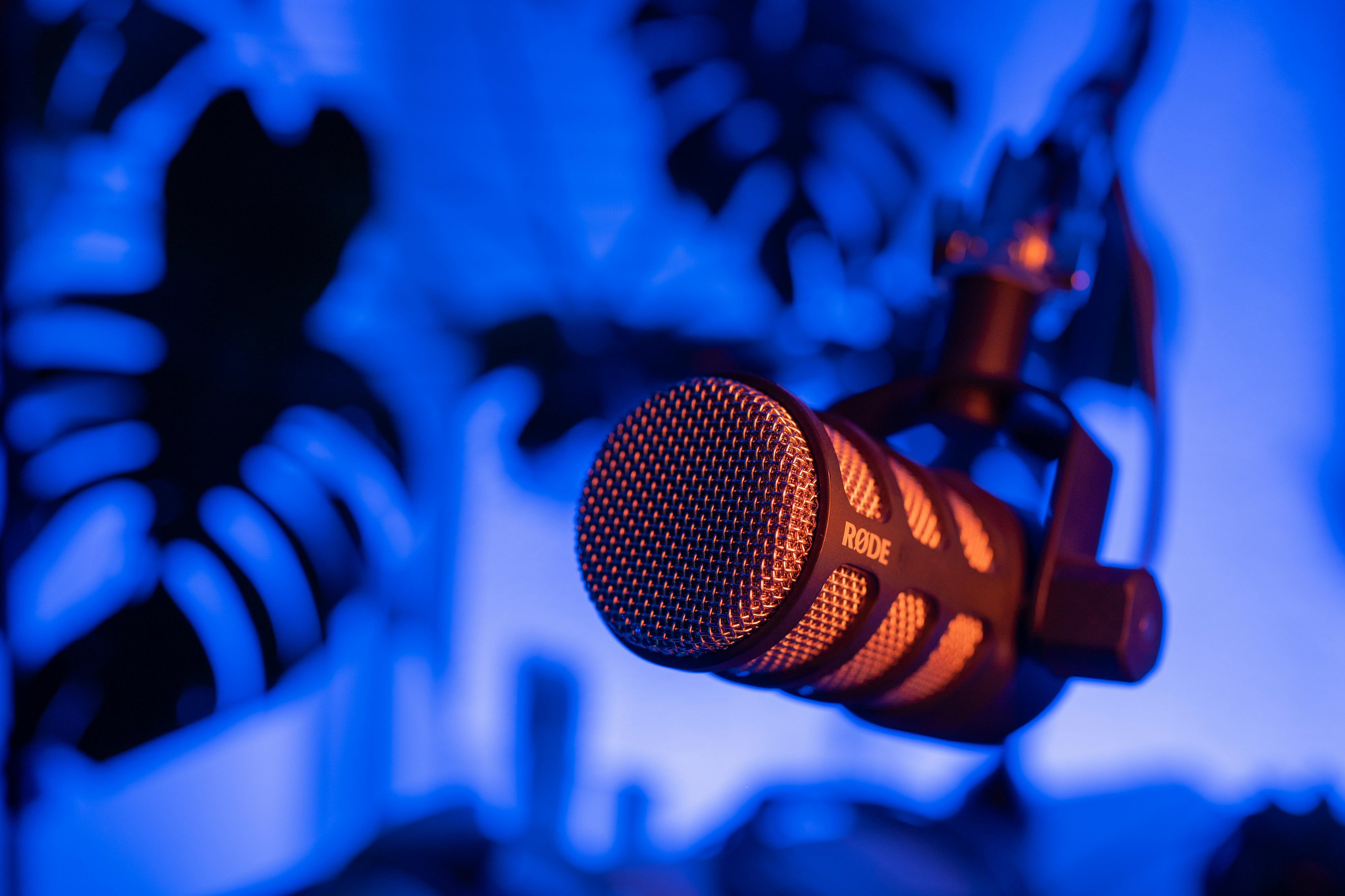A microphone in front of a neon blue background