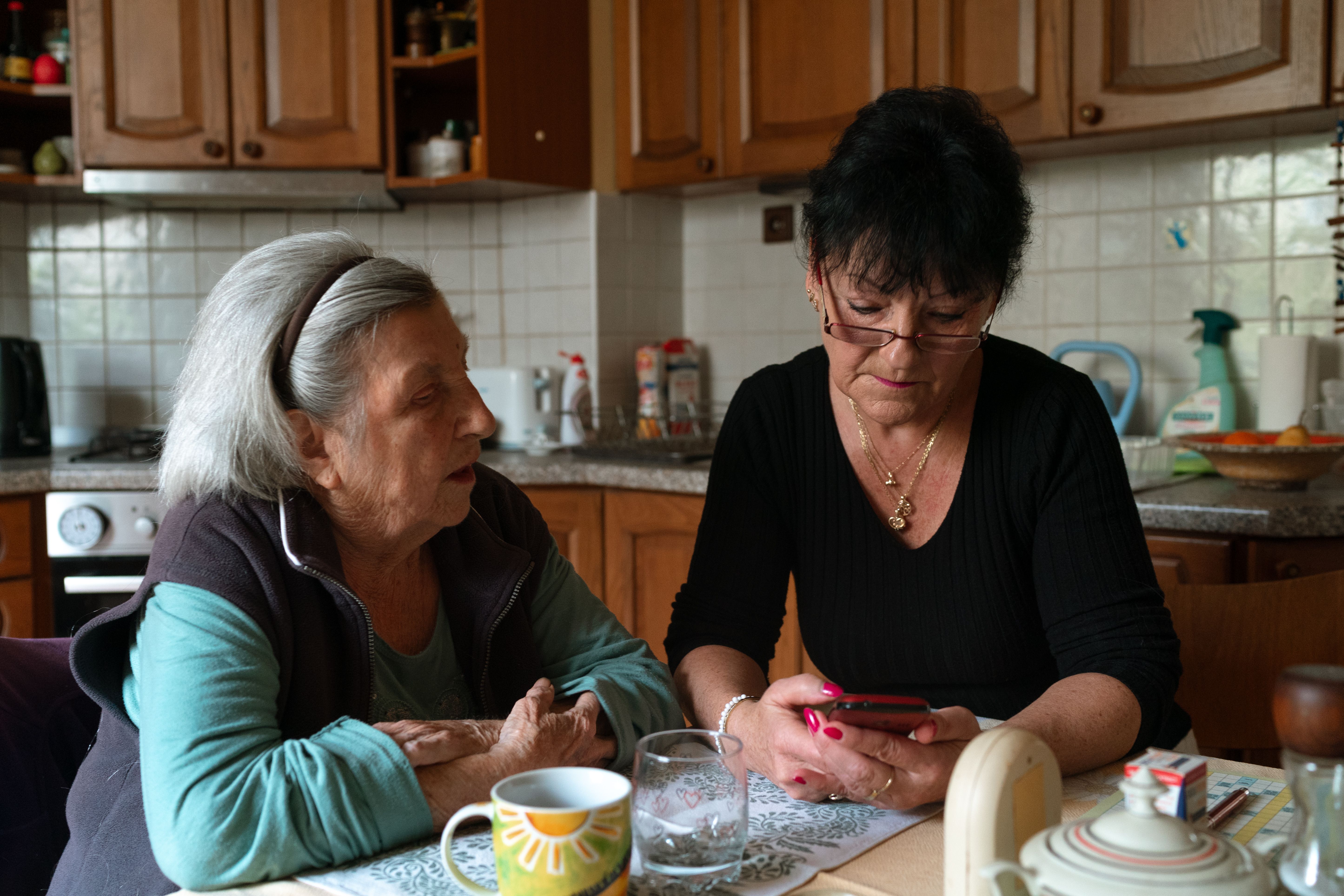 l older ladies sat at a kitchen table