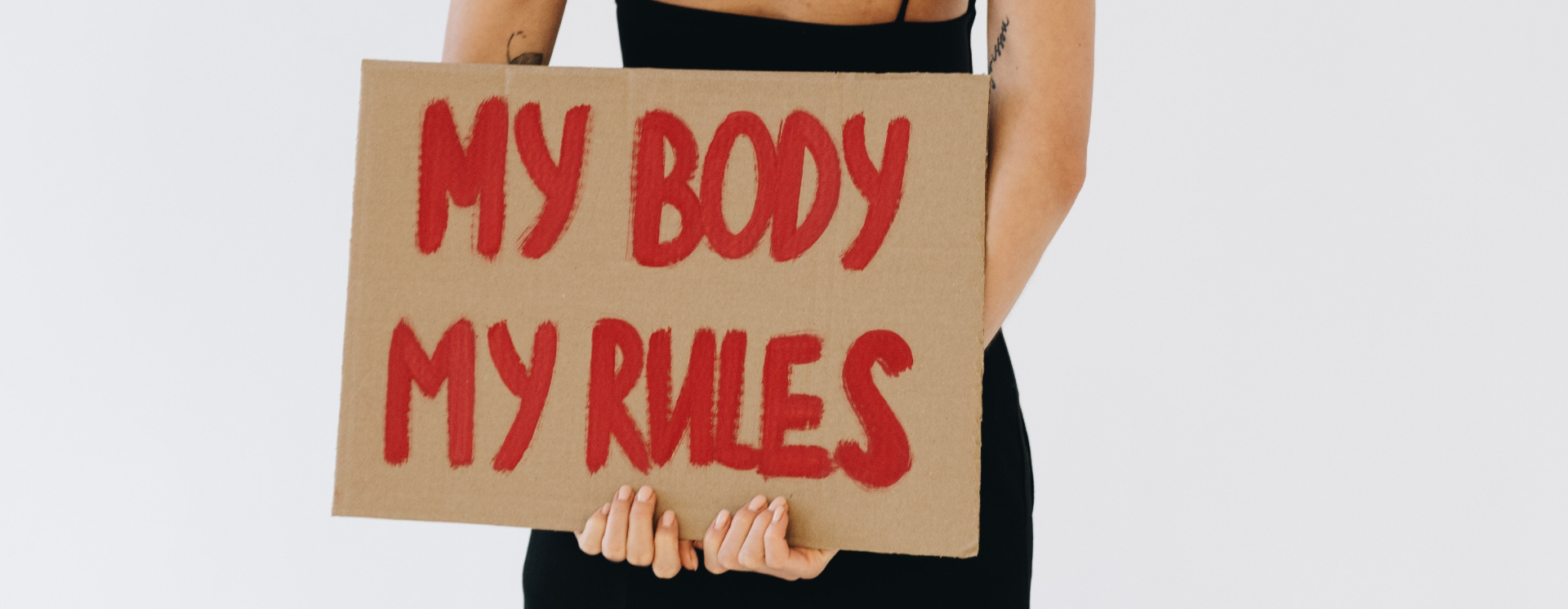 A woman holding a sign that says, 'My body, my rules.'