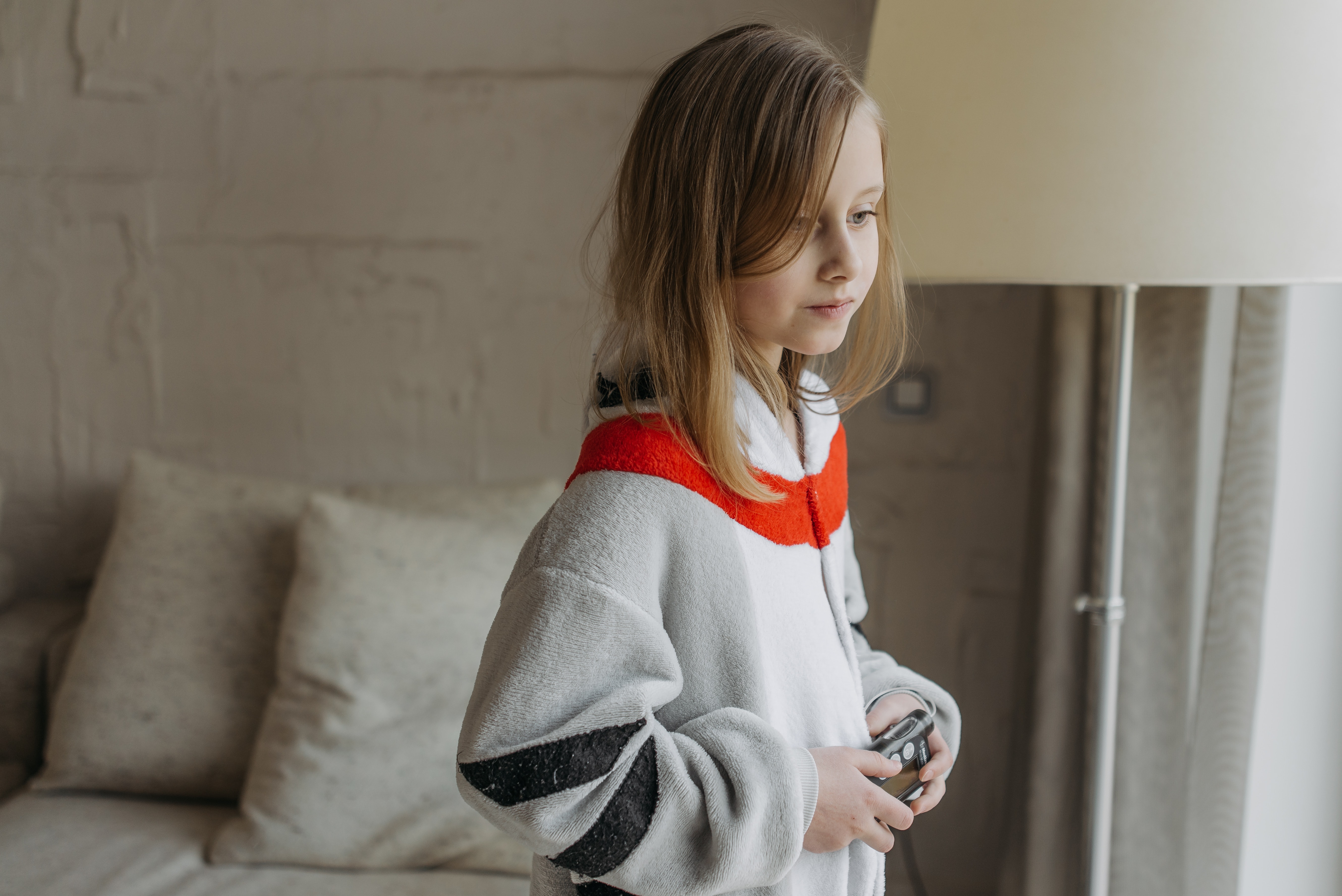 A young girl wearing a onesie holding an insulin pump