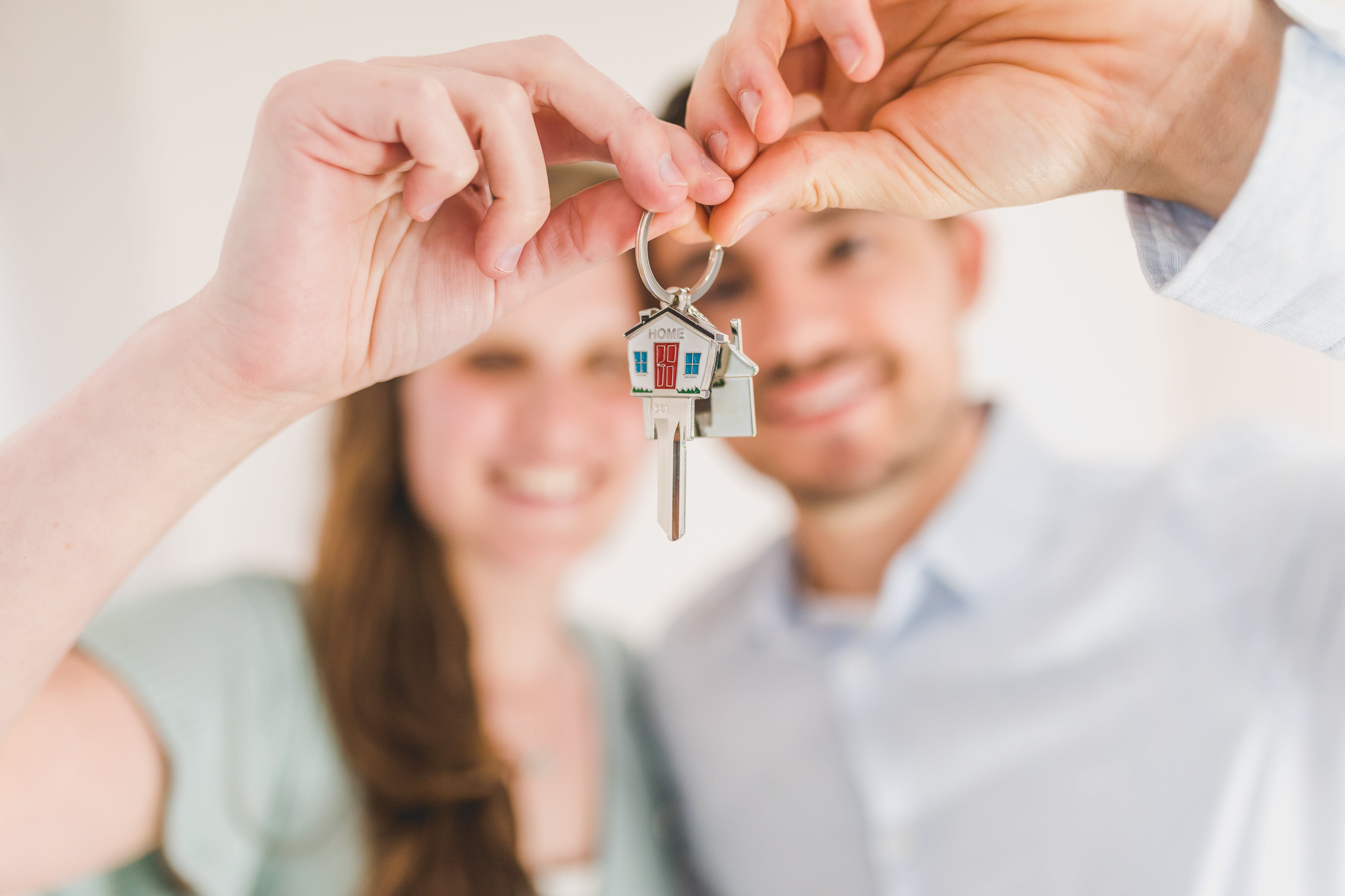 A young couple holding a set of house keys.