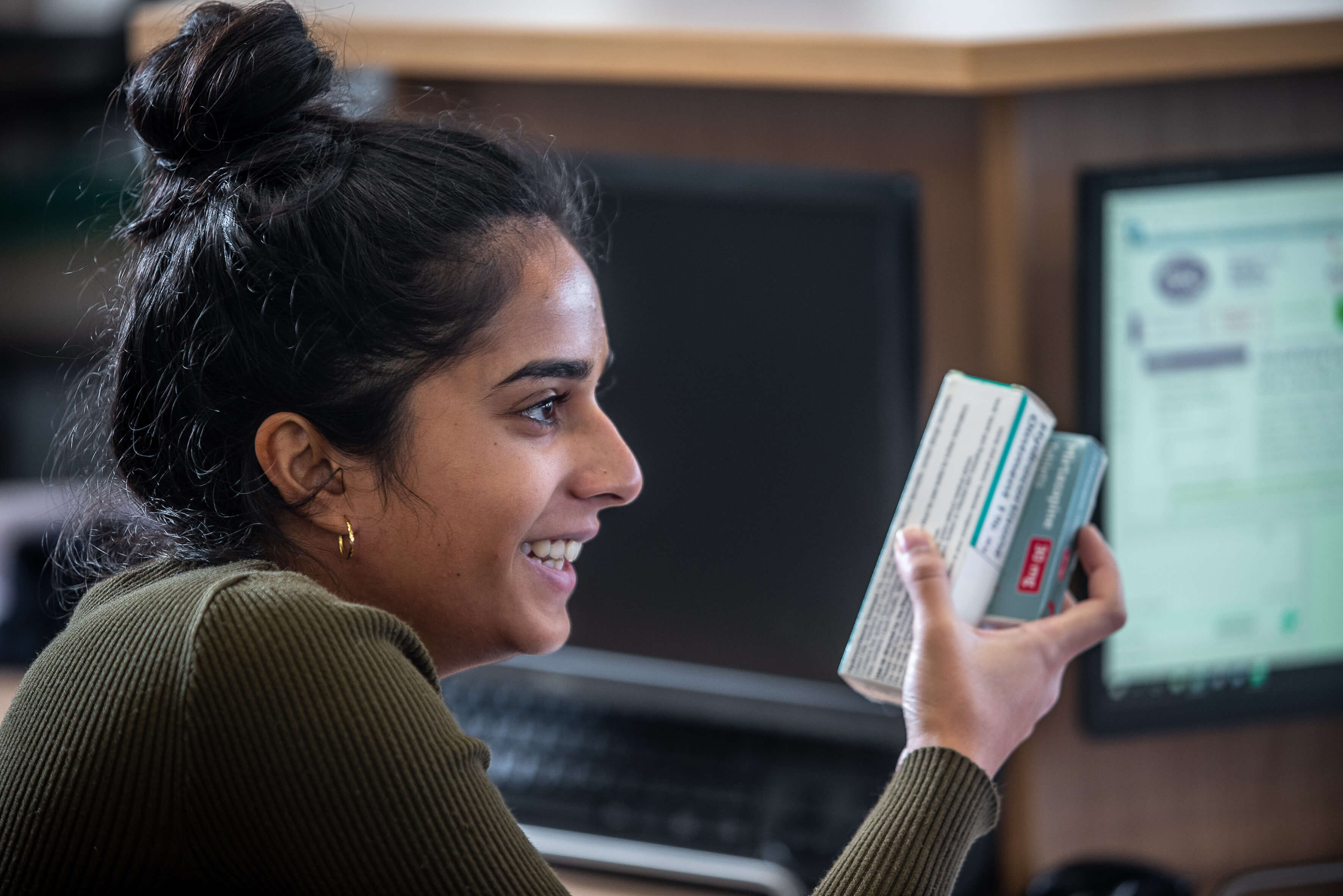 Pharmacy students holding box of medication
